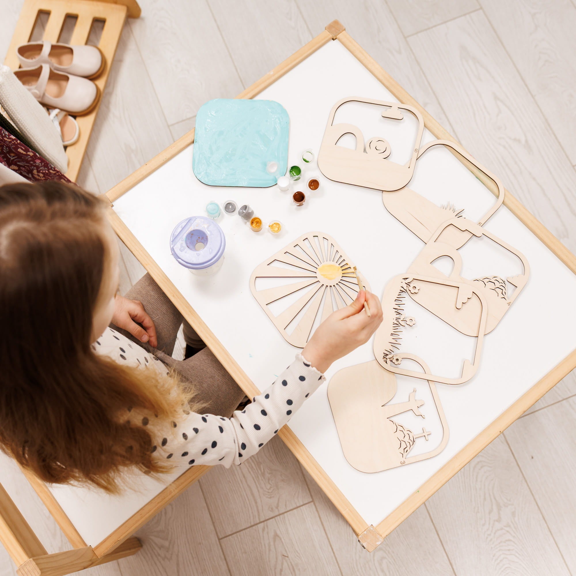 Child playing with wooden toys on a table