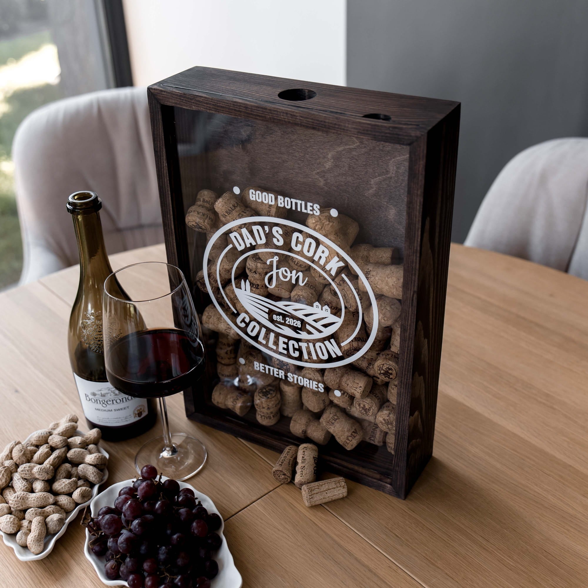 A dark wood wine cork display box with a clear front panel