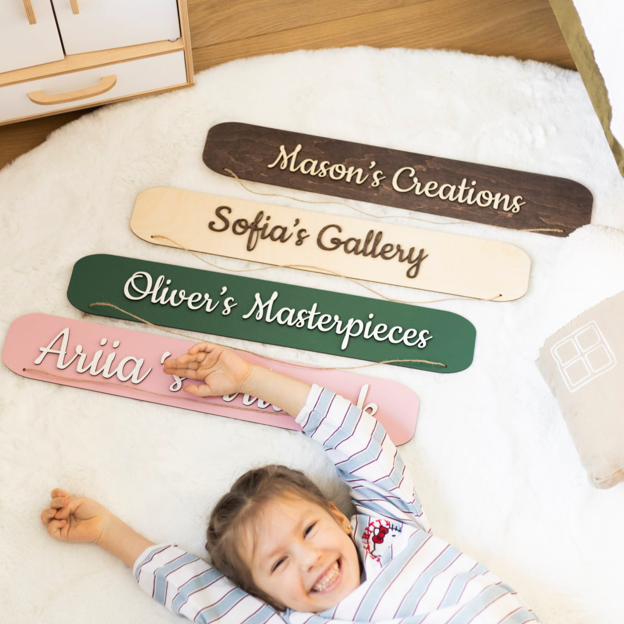 Children's nameplates on a bed with a child lying underneath