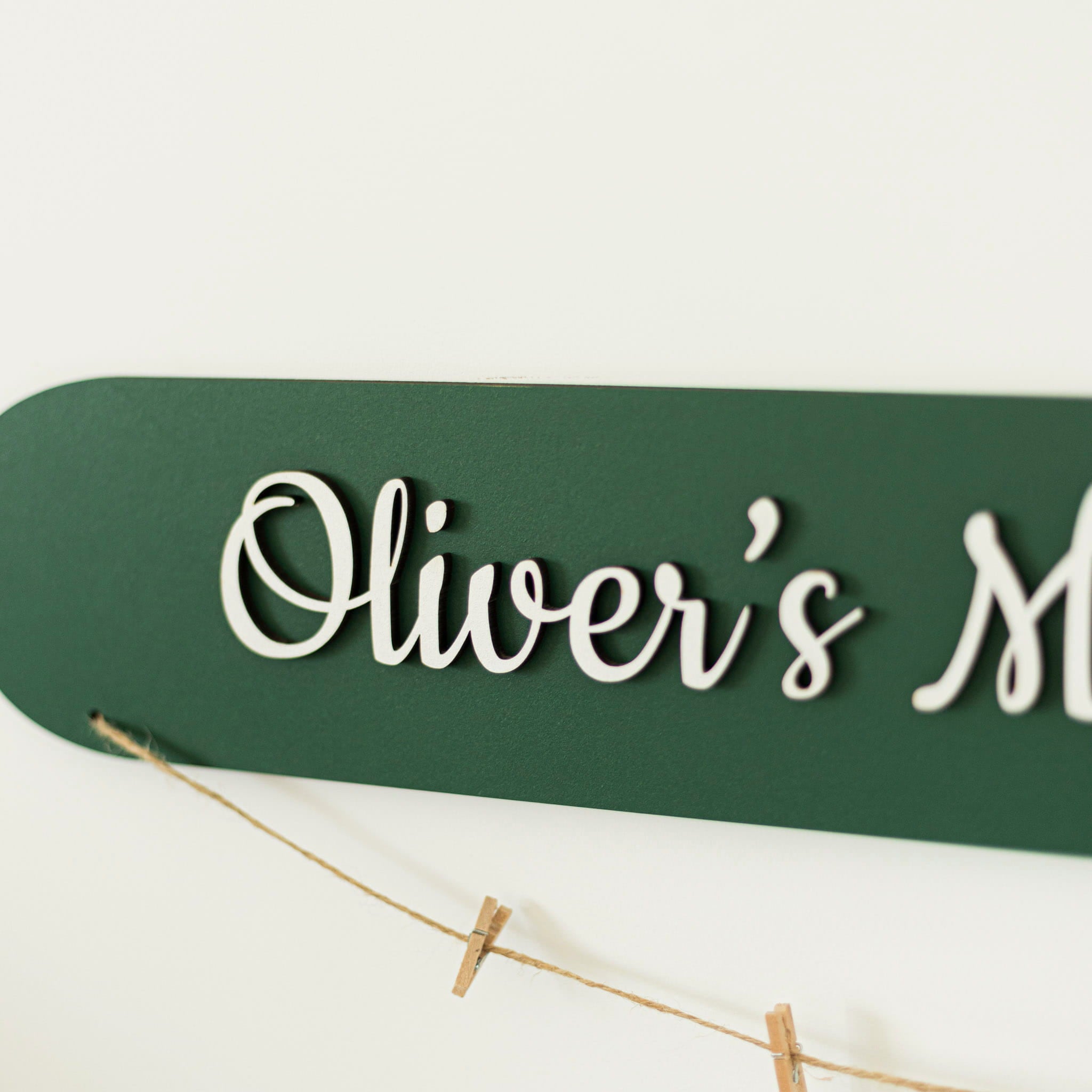 Green sign with 'Oliver's' in white cursive text on a light background