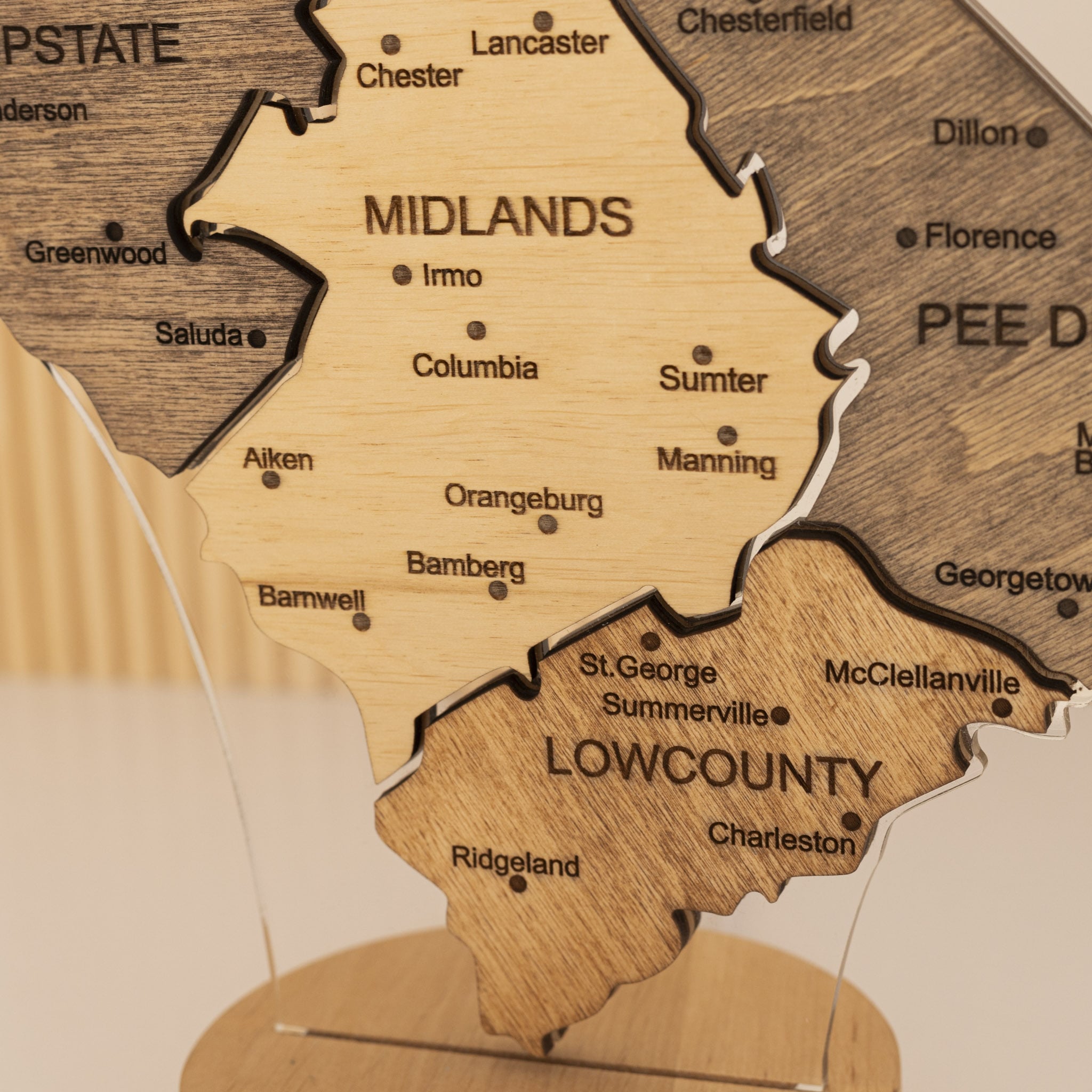 Wooden map of a region with labeled cities on a beige background