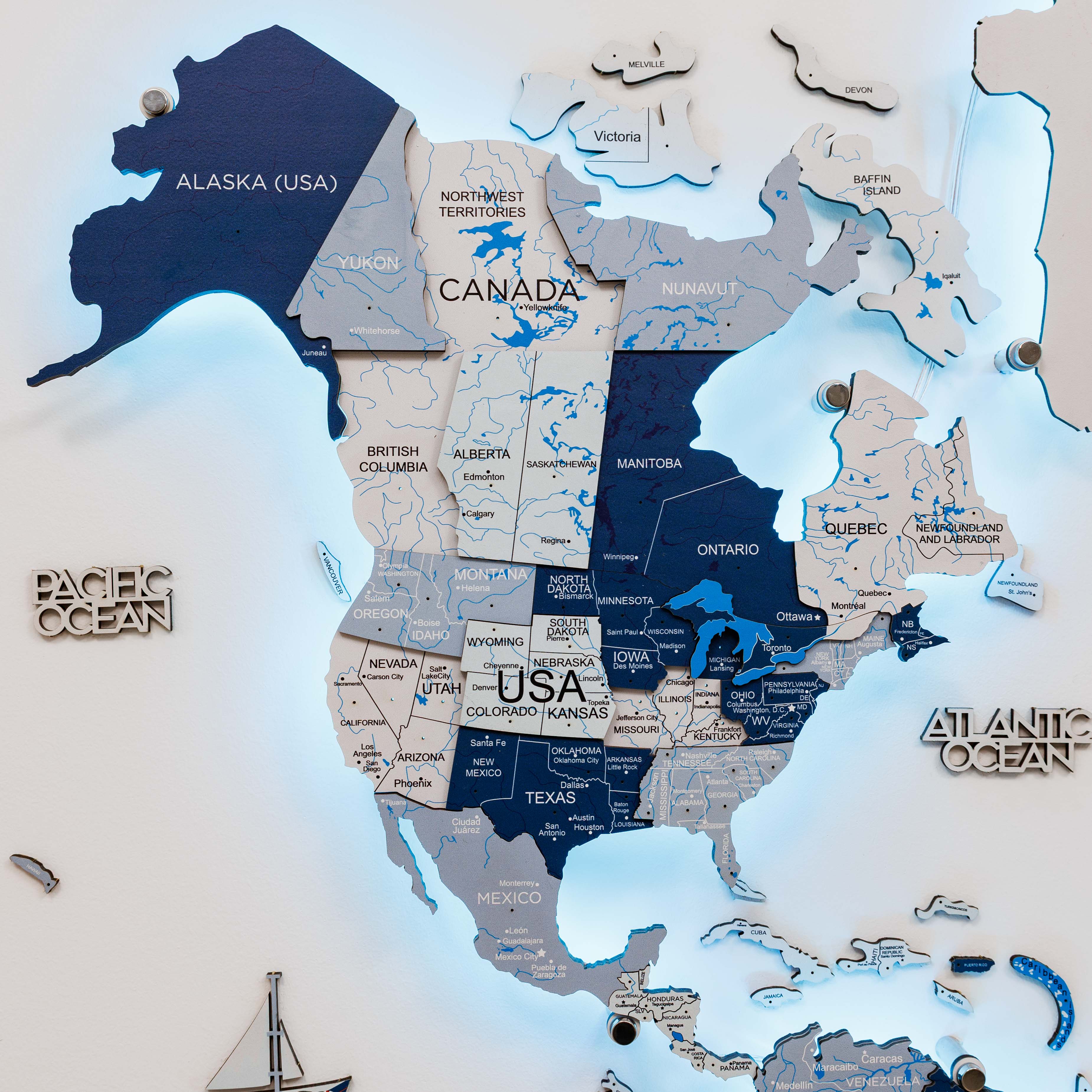 Wooden map of North America with labeled states and countries on a white background