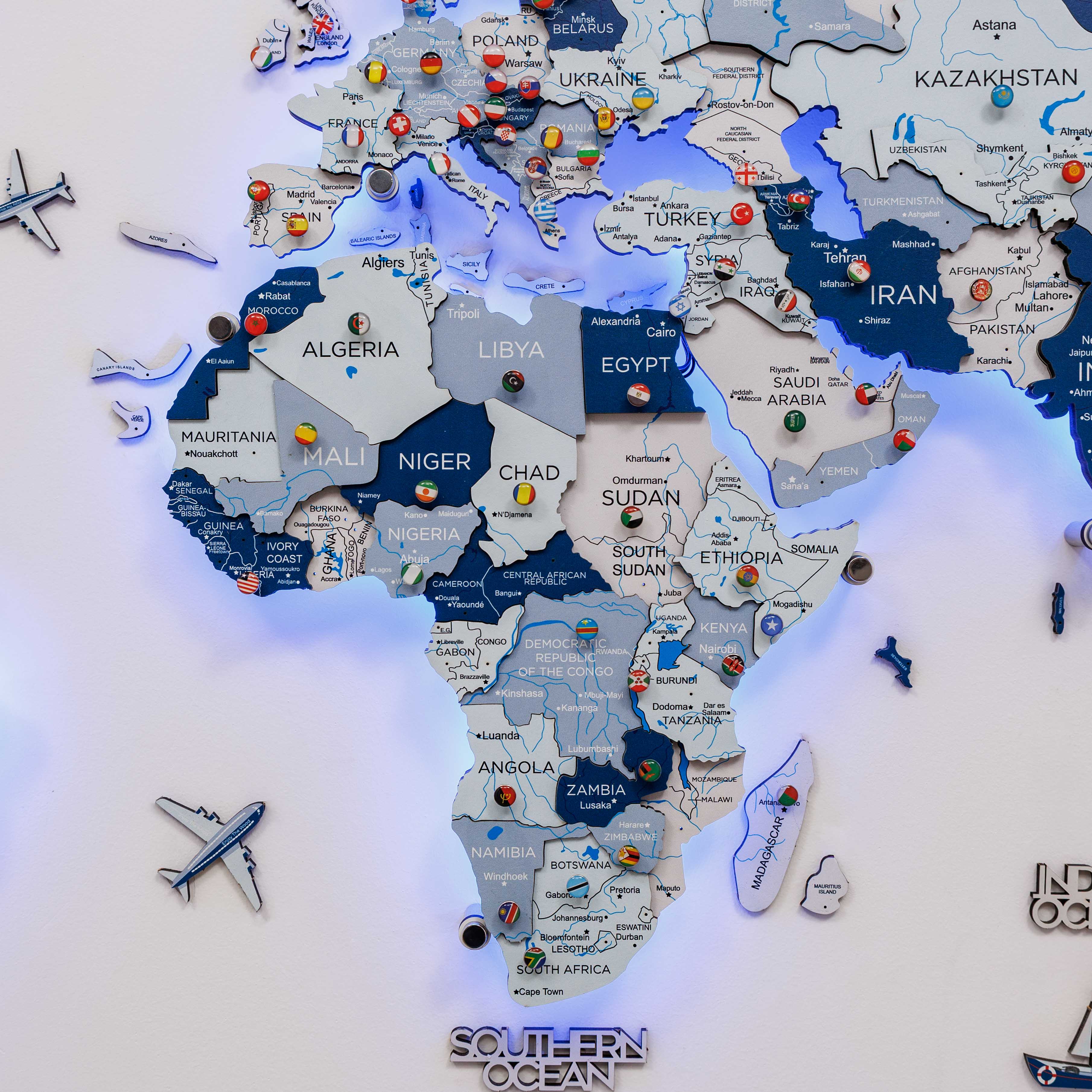 Map of the world with pins and airplane symbols on a light-up board