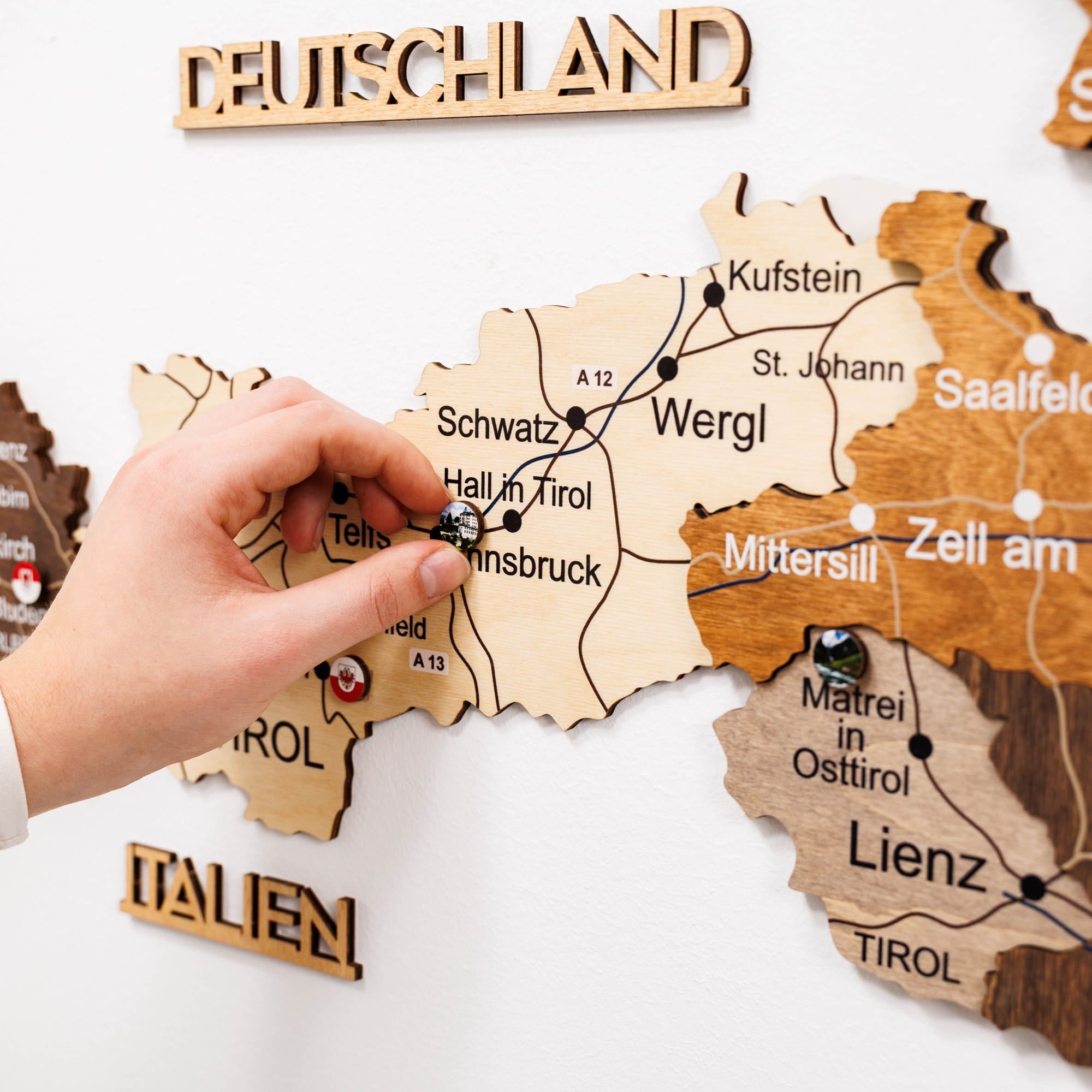 Wooden map of Germany with a hand placing a small object on it