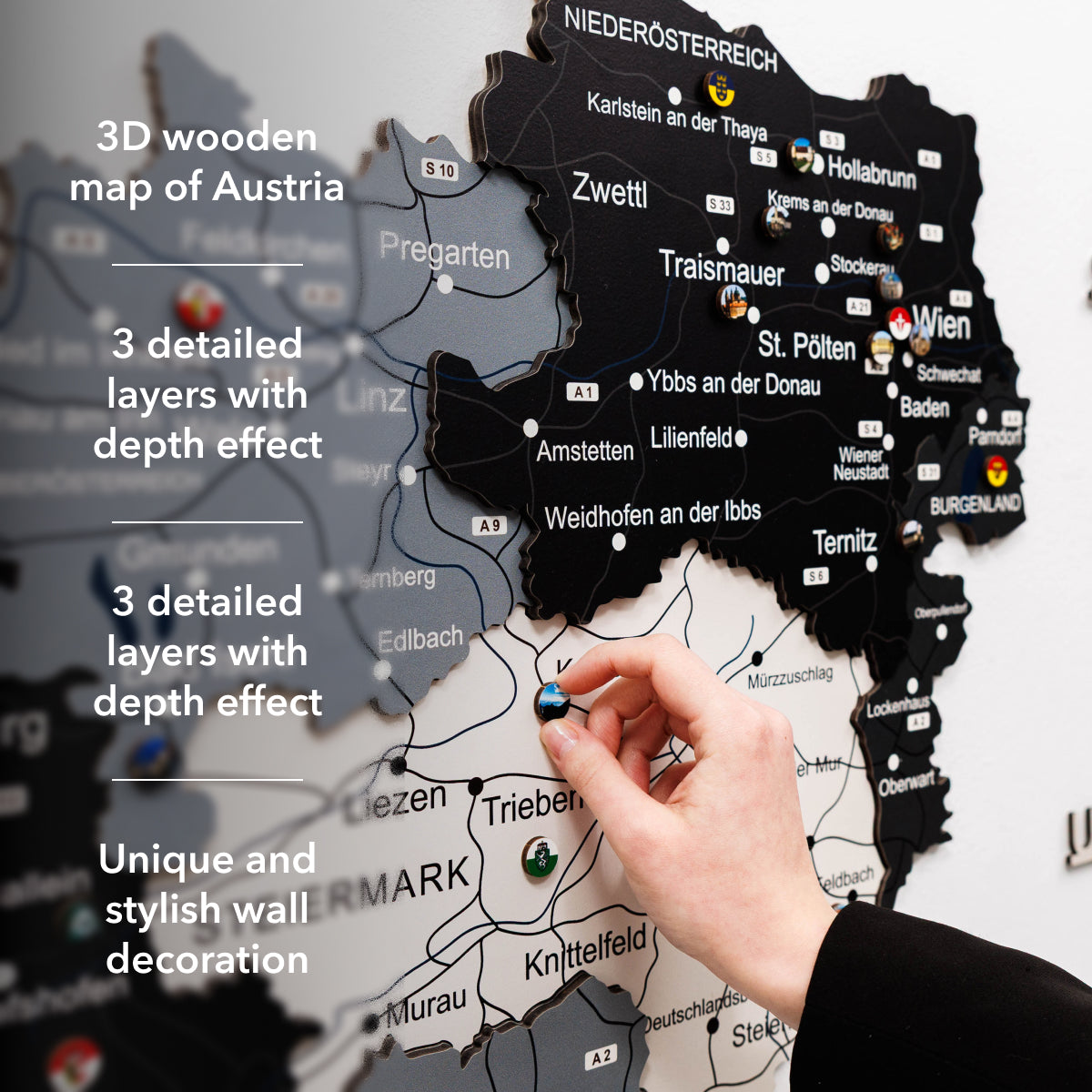 3D wooden map of Austria with a hand placing a small object on it