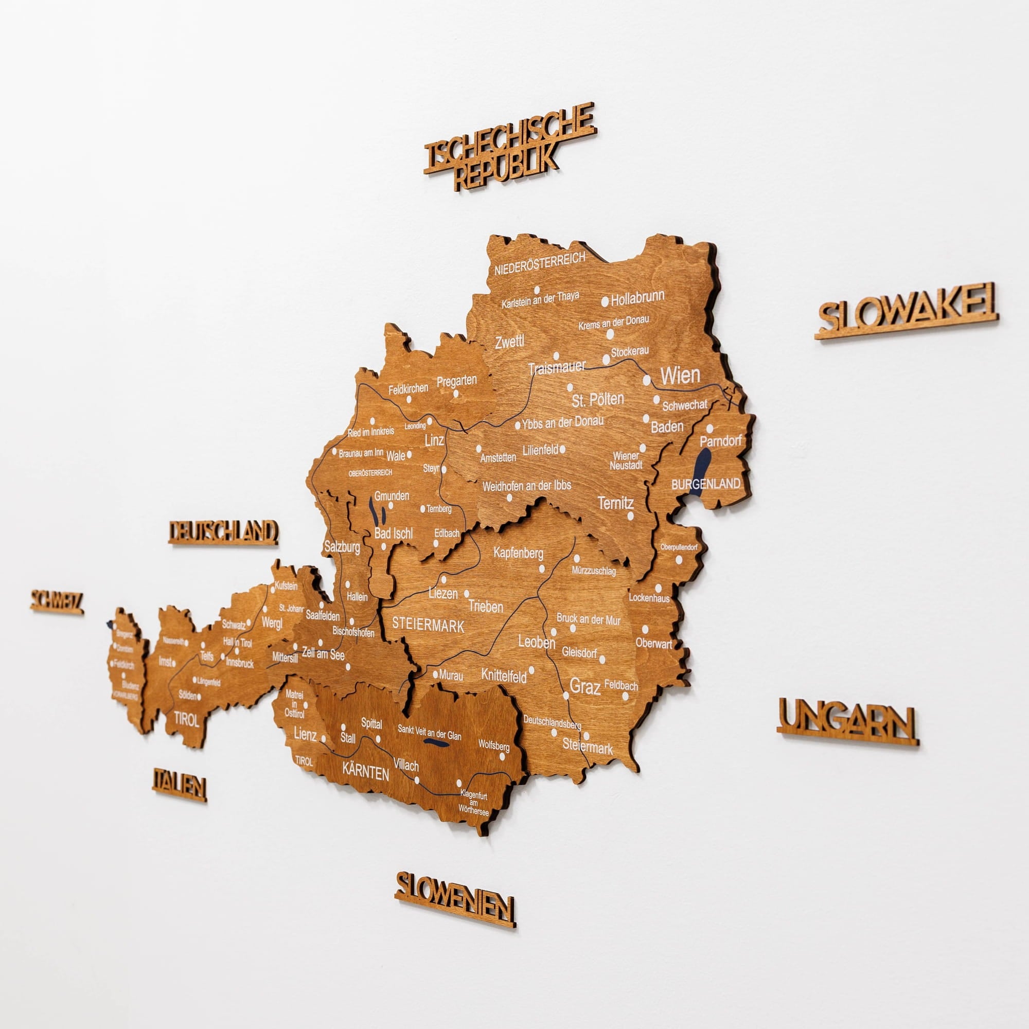 Wooden map of Austria with city names on a white background
