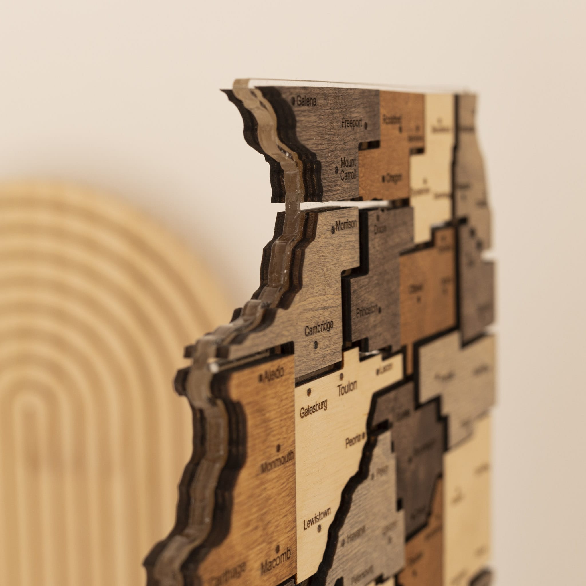 Wooden wall art with cut-out shapes and text on a neutral background