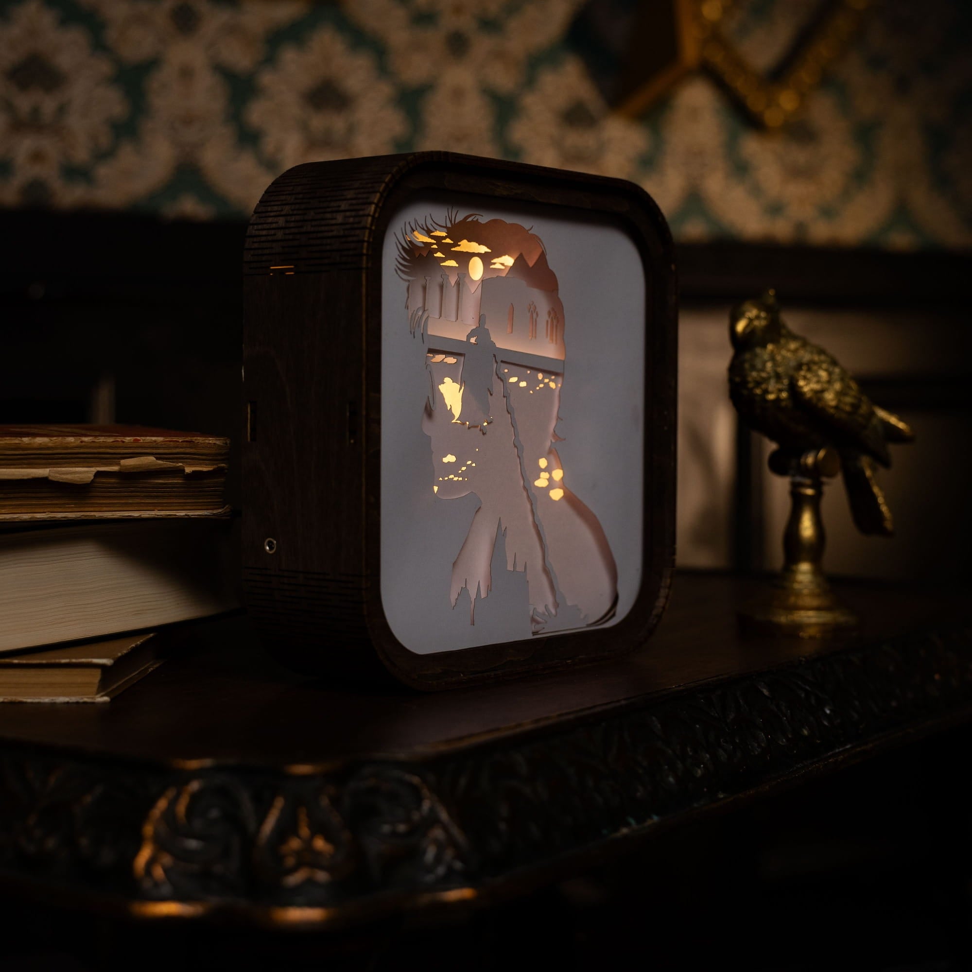 Vintage-style television set with a silhouette of a woman holding a lamp on a decorative shelf.