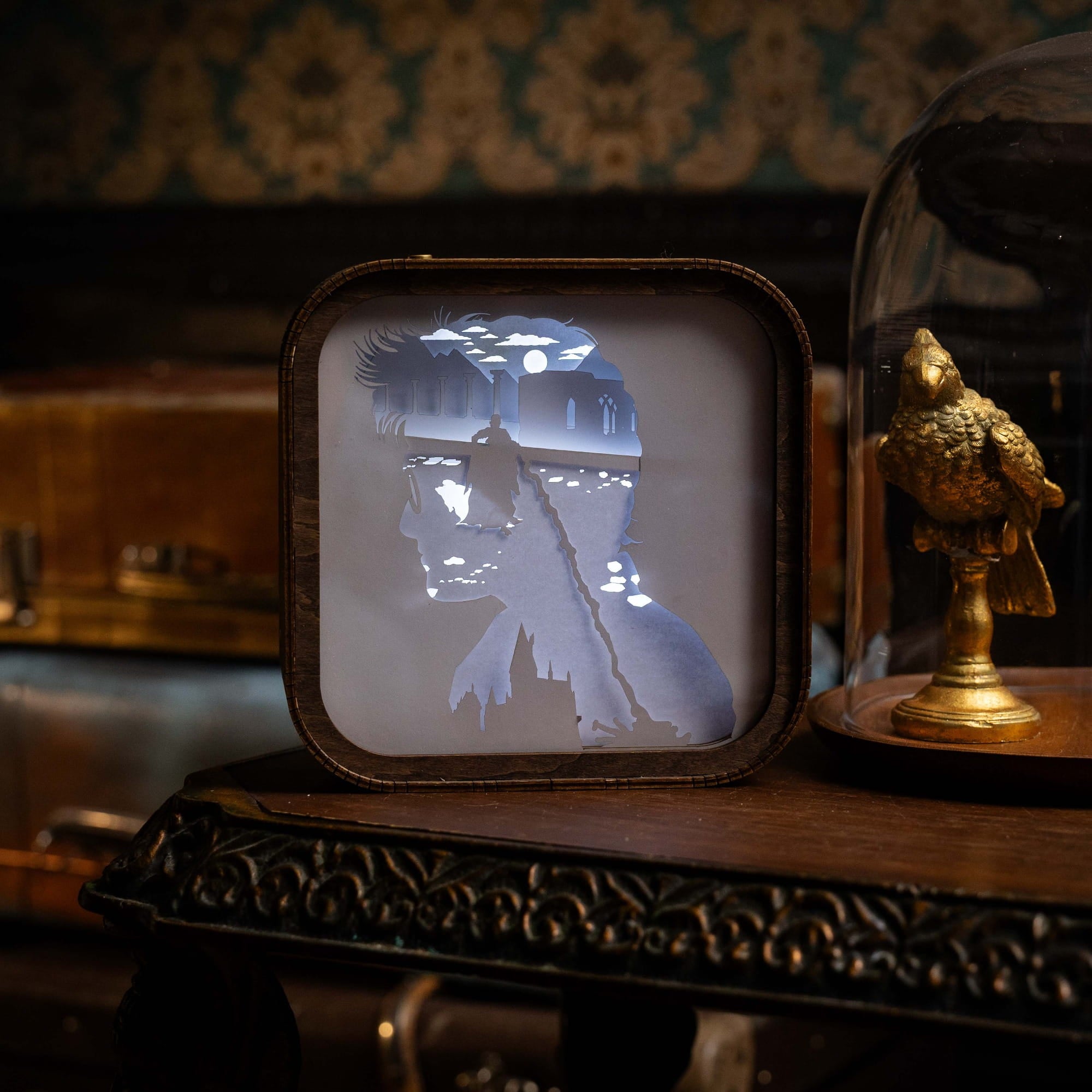 Decorative light box with silhouette of a person and horse on a wooden surface.