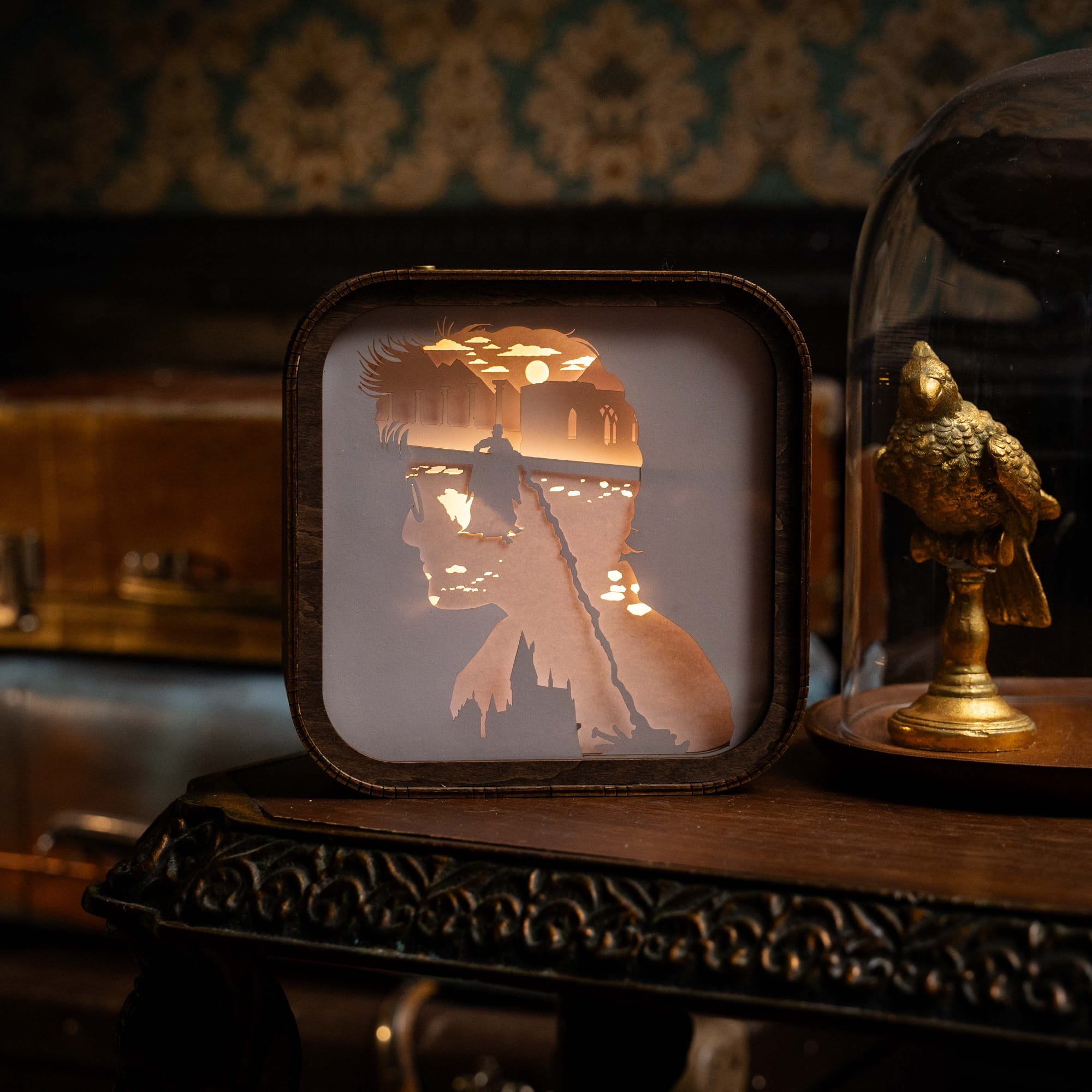 Decorative light box with a silhouette of a person holding a candle, set against a vintage-style background.