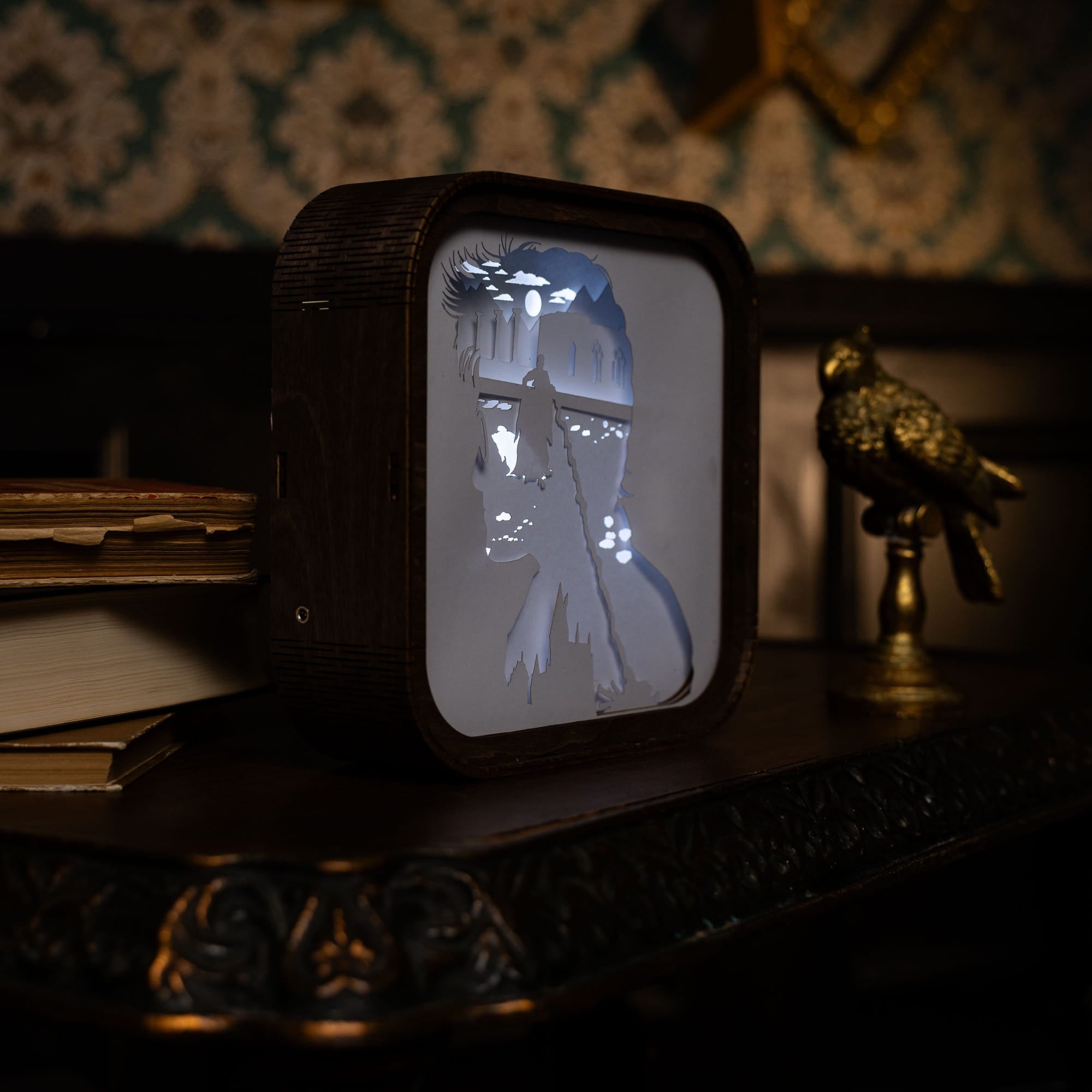 Vintage-style television set with a silhouette of a person on its screen, placed on a wooden surface.