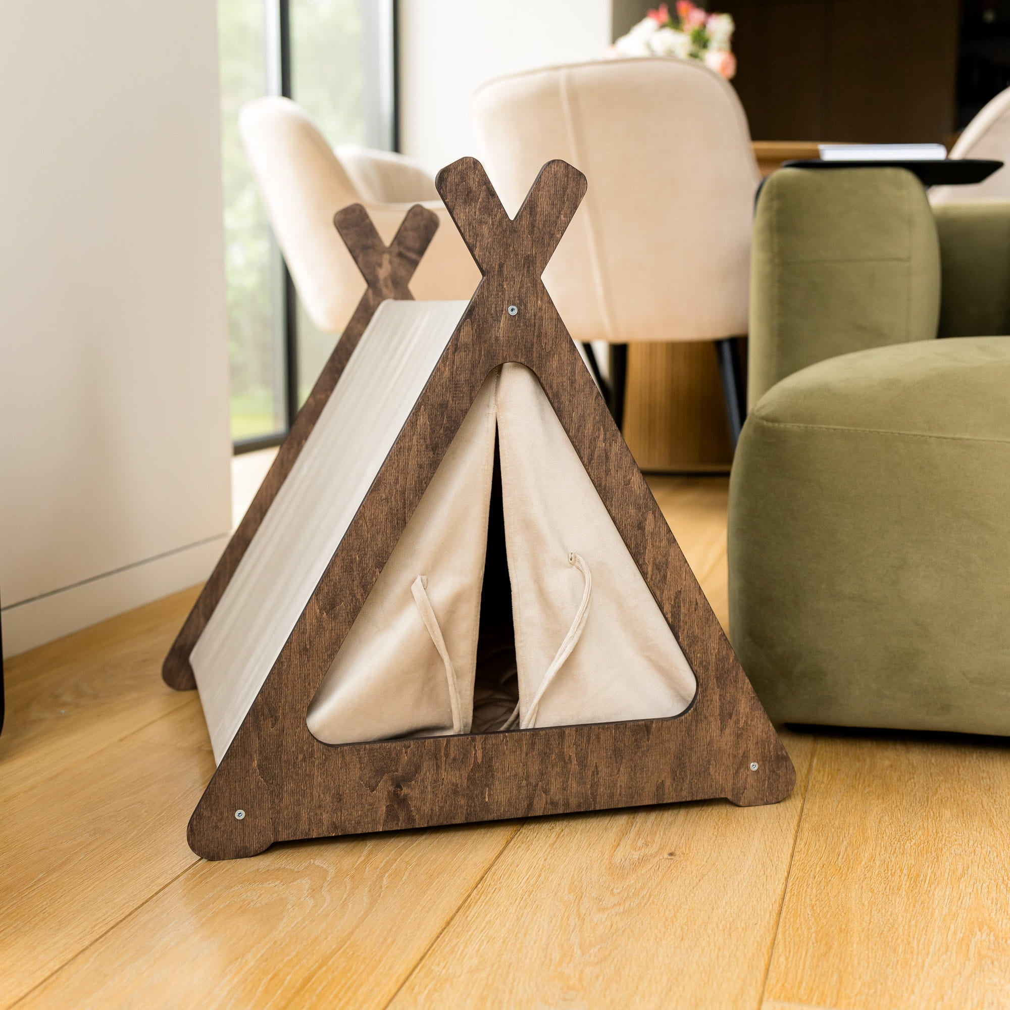 Wooden pet teepee on a wooden floor with a blurred background