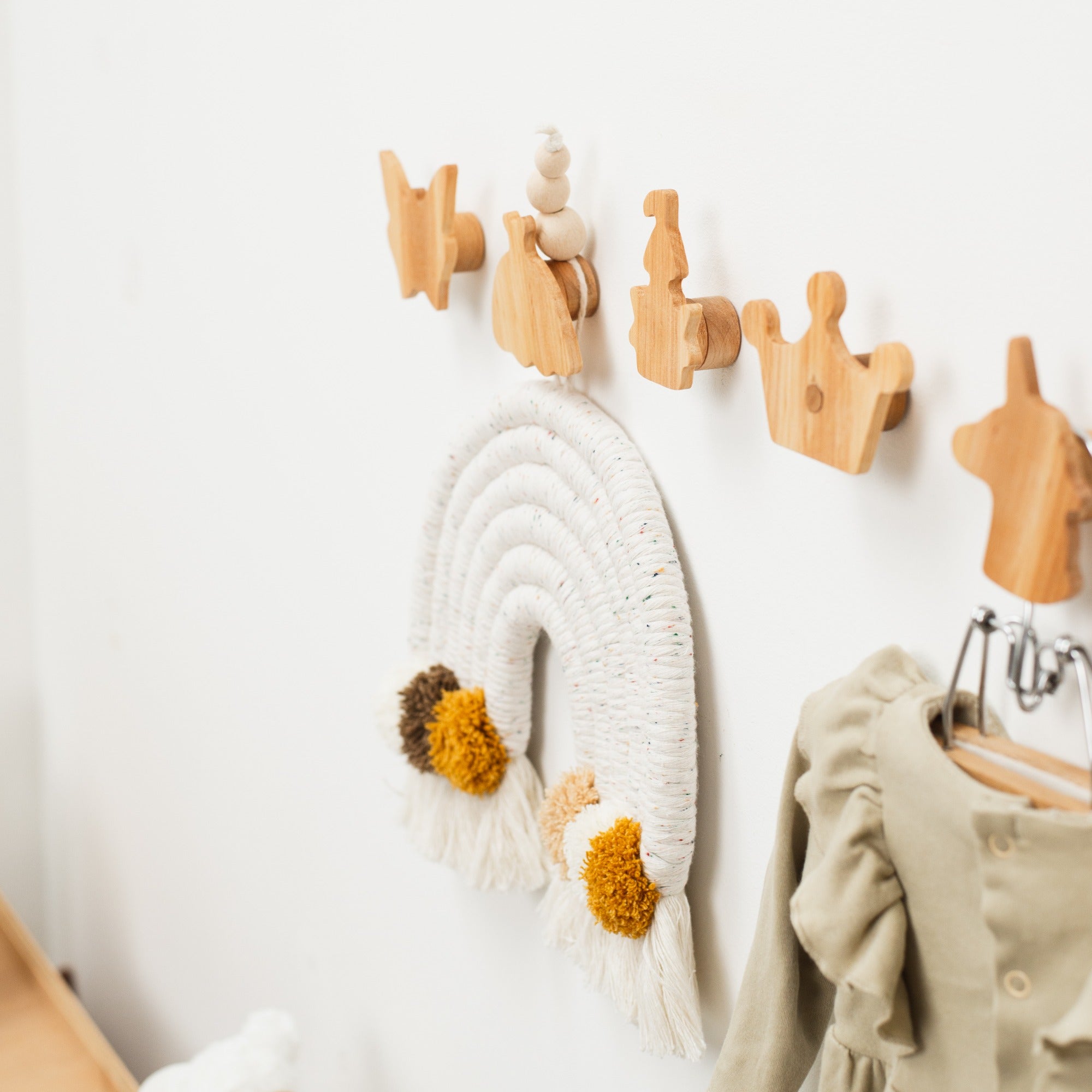 Wooden wall hooks with decorative items on a white wall