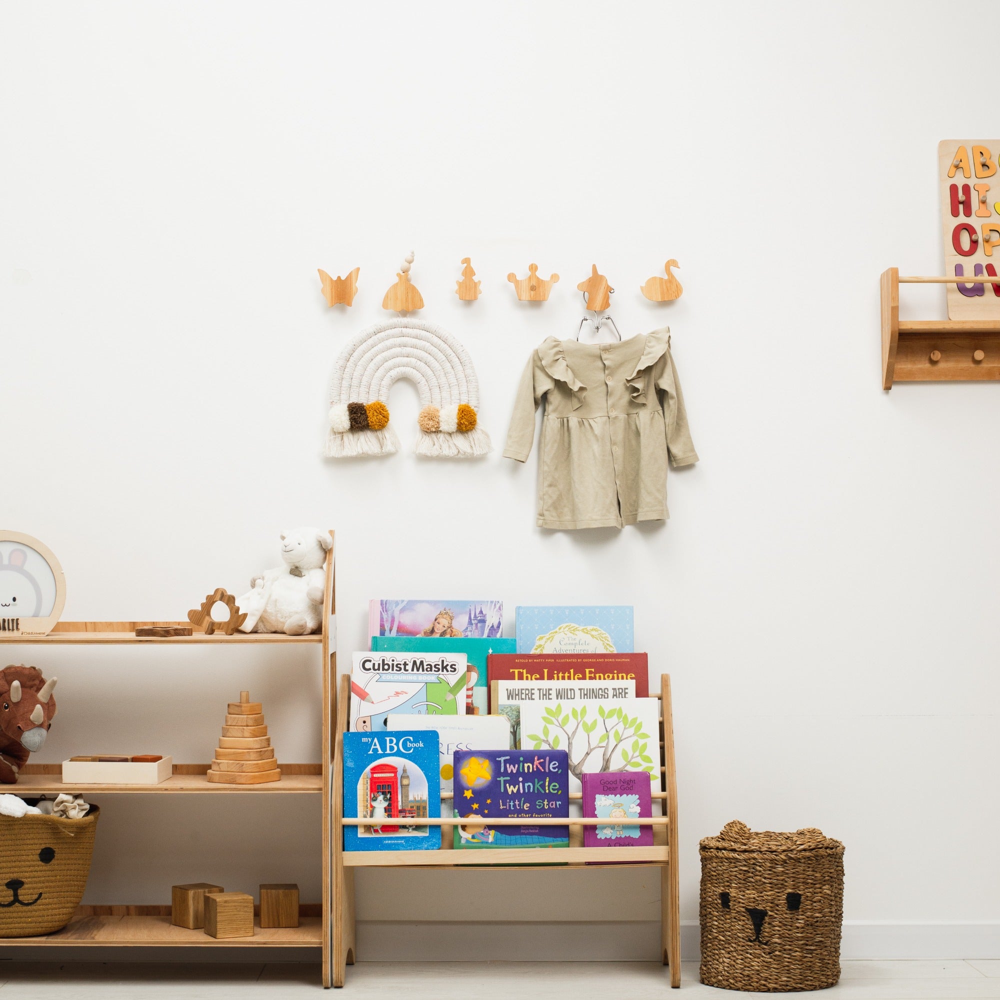 Children's room with shelves, books, and toys against a white wall.