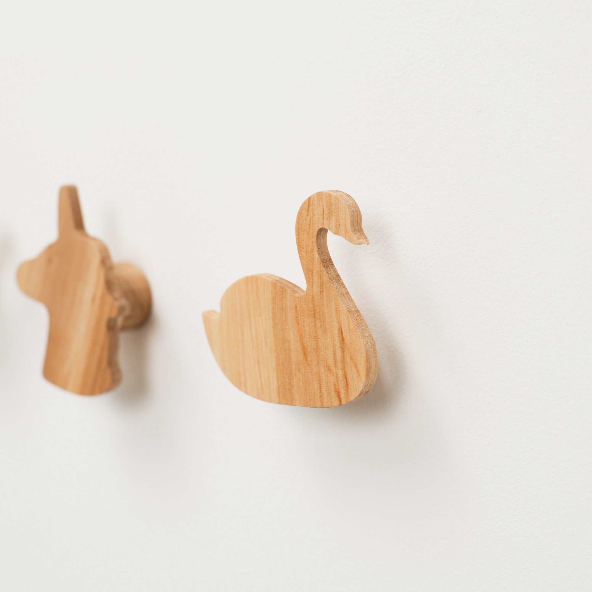 Two wooden swan-shaped objects on a white background