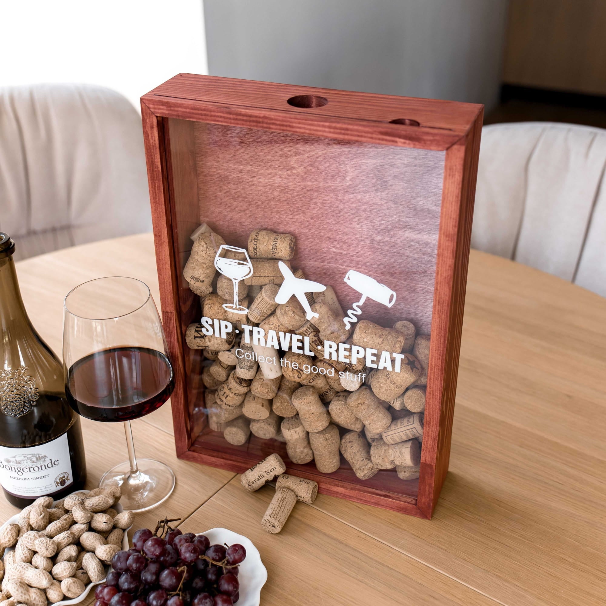 A wooden shadow box gift box with a clear front panel sits on a wooden table