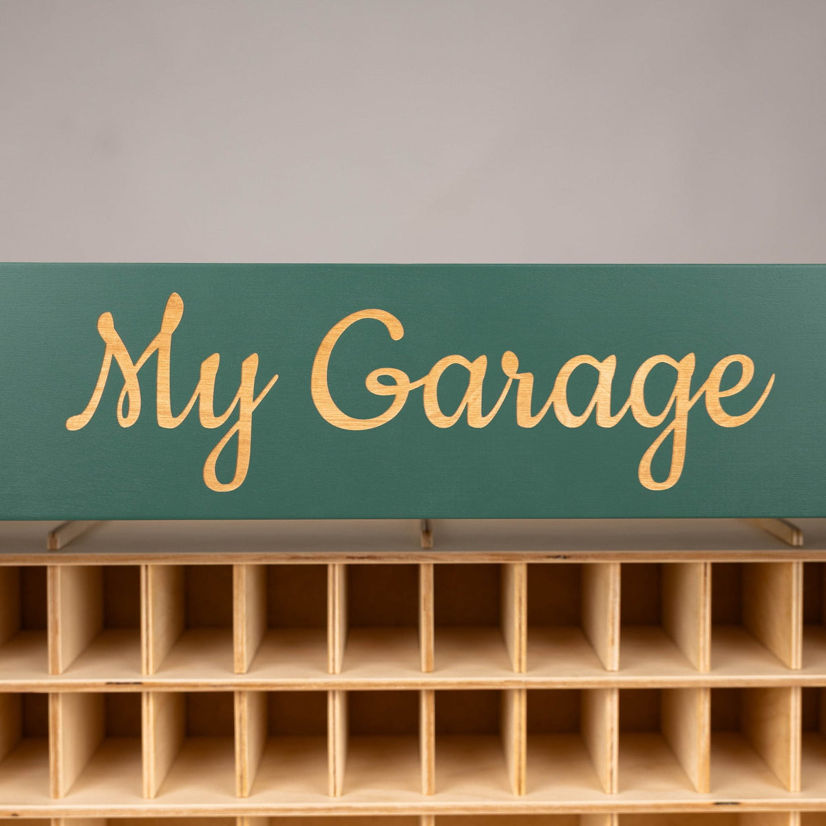 The playset has multiple storage cubbies, a ramp, and several toy cars, with the words "My Garage" painted on the front.