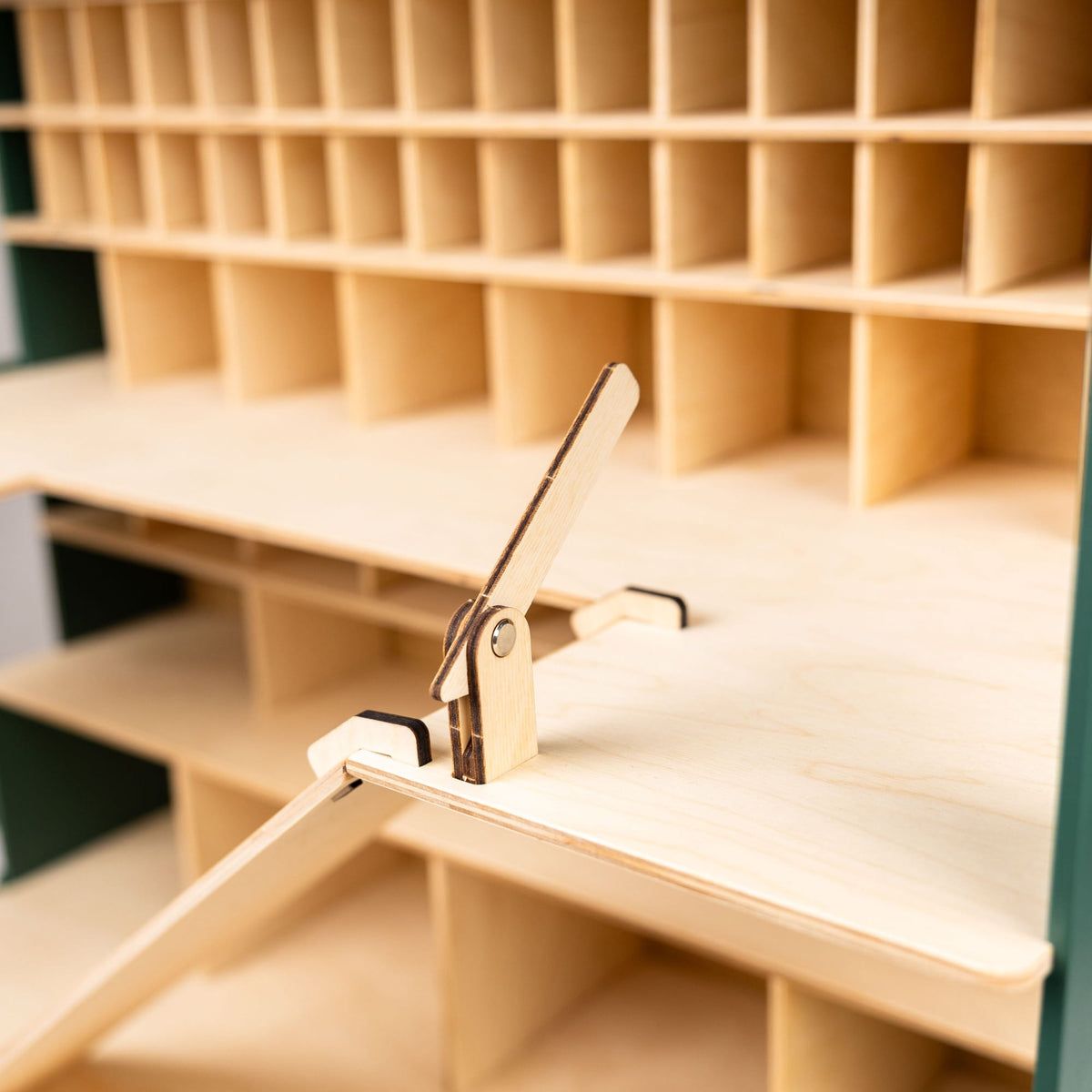 Close-up of a light natural wood sorting tray or organizer with a small metal clip