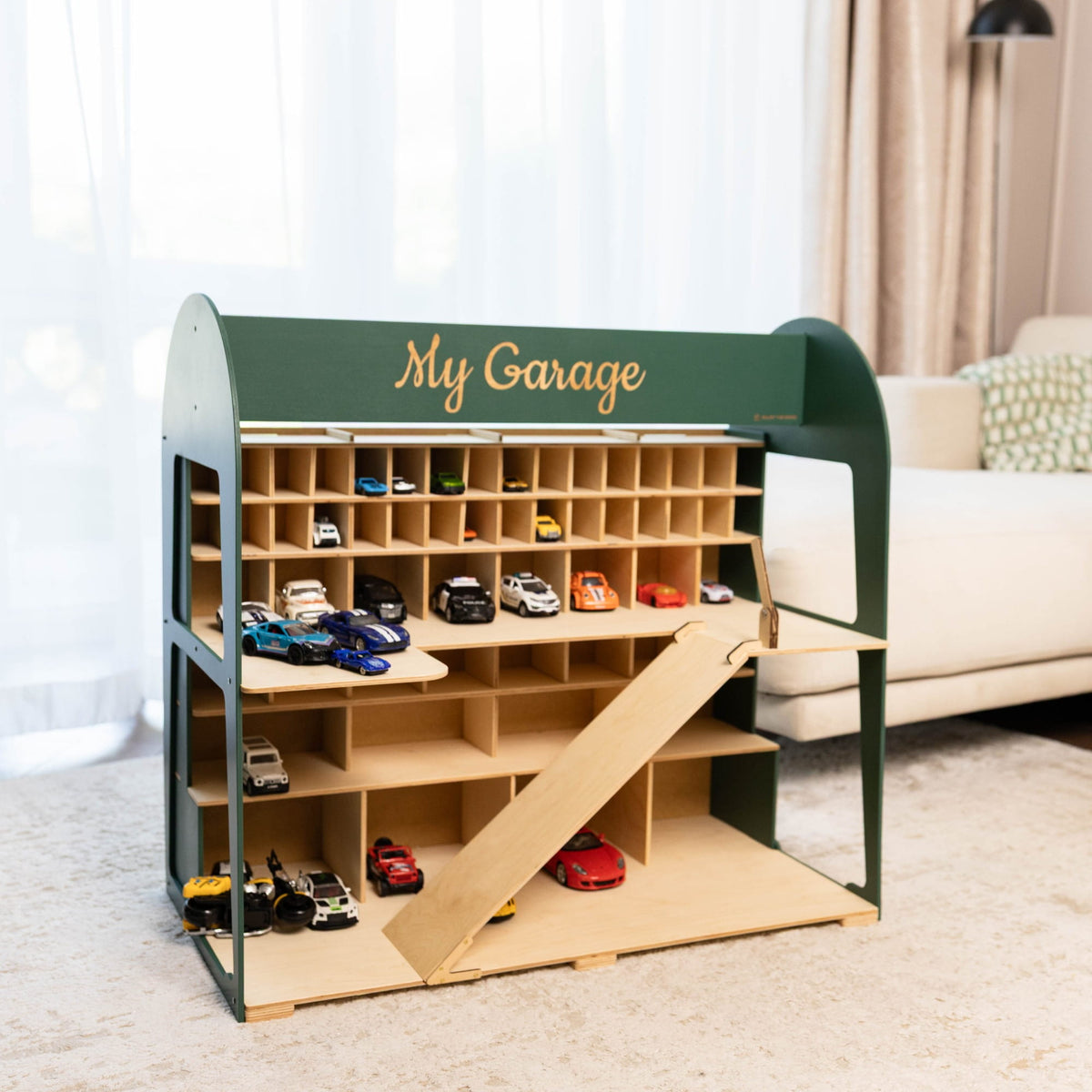  children's wooden garage playset with a green frame and light natural wood compartments