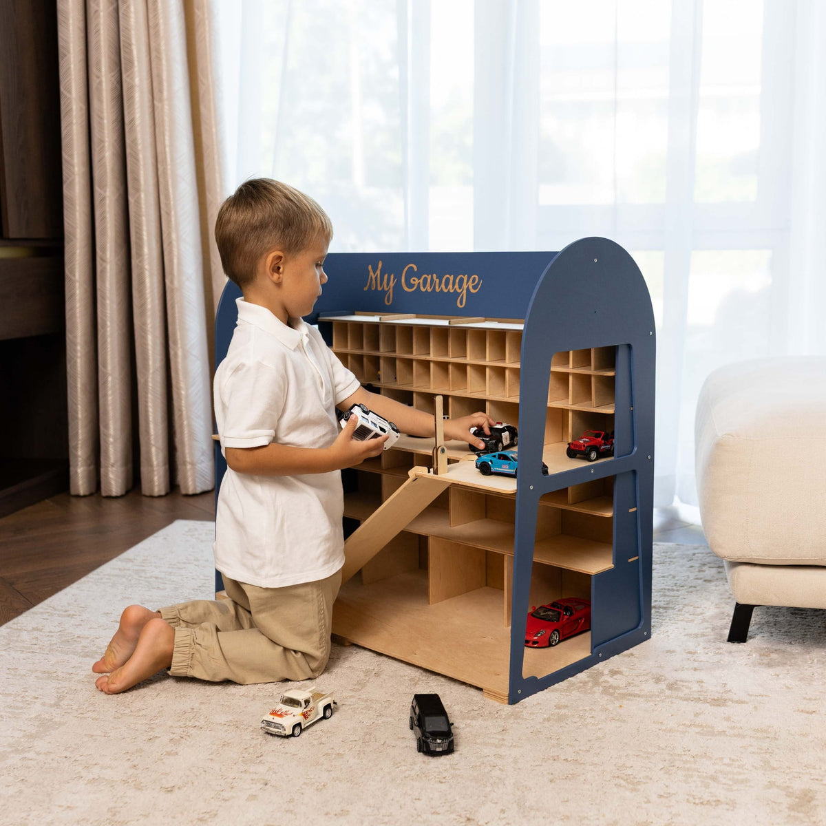 The garage is navy blue on the exterior with natural light wood shelves and compartments, and has 'My Garage' written on the front in gold.