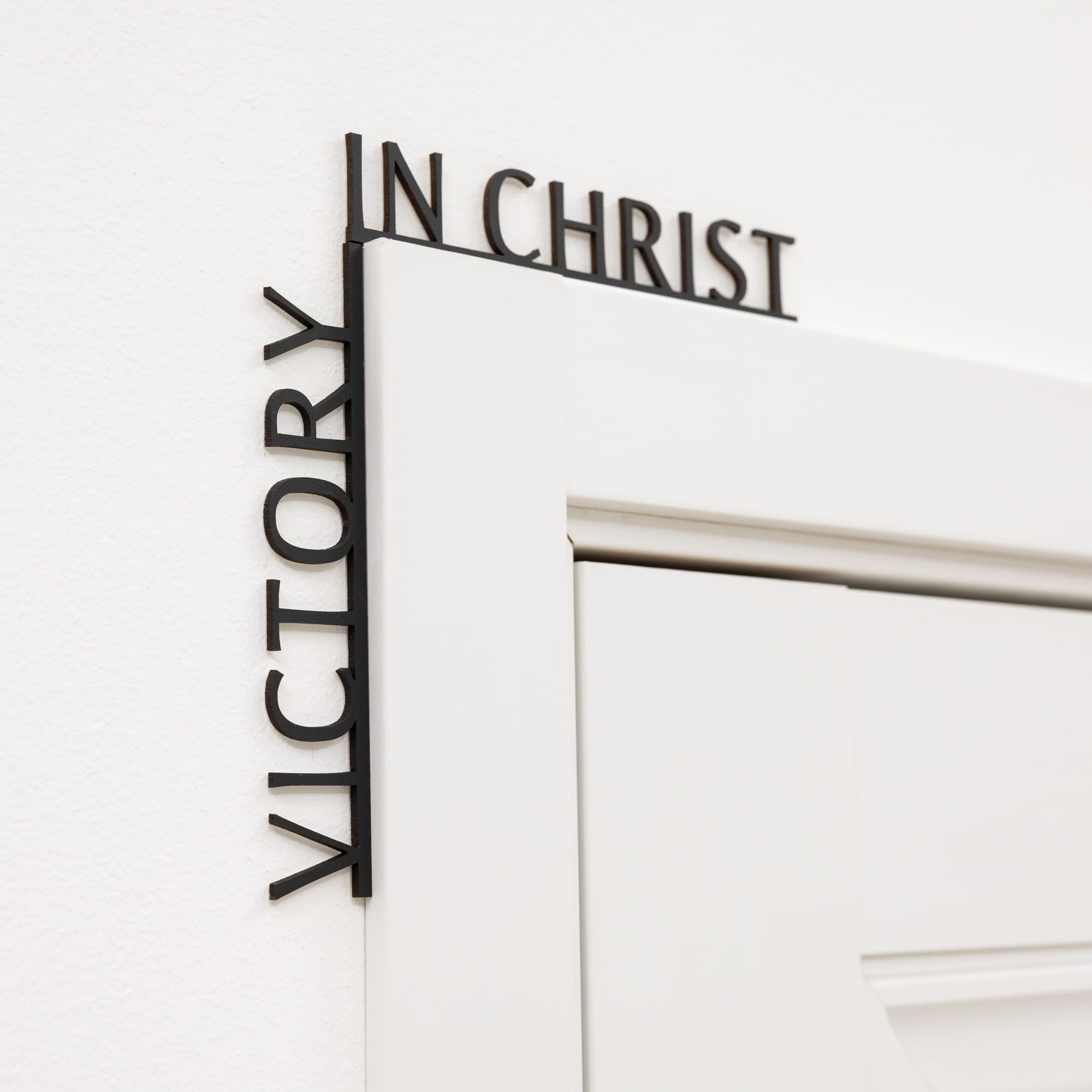 Decorative wall art with 'Victory in Christ' text on a white background