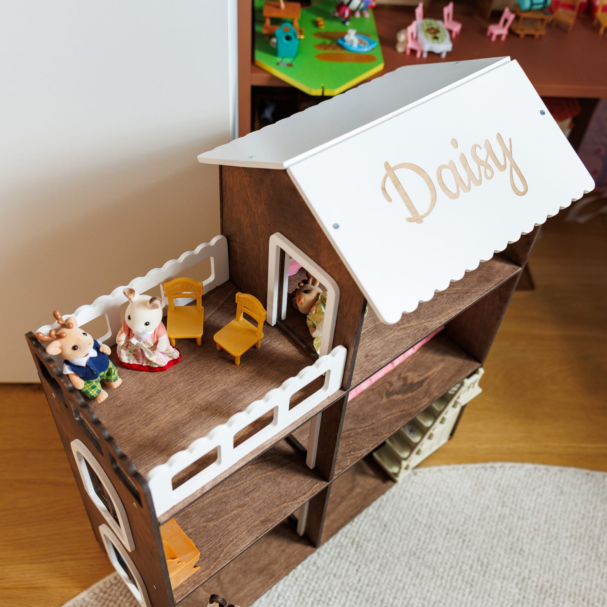 wooden dollhouse with a white scalloped roof