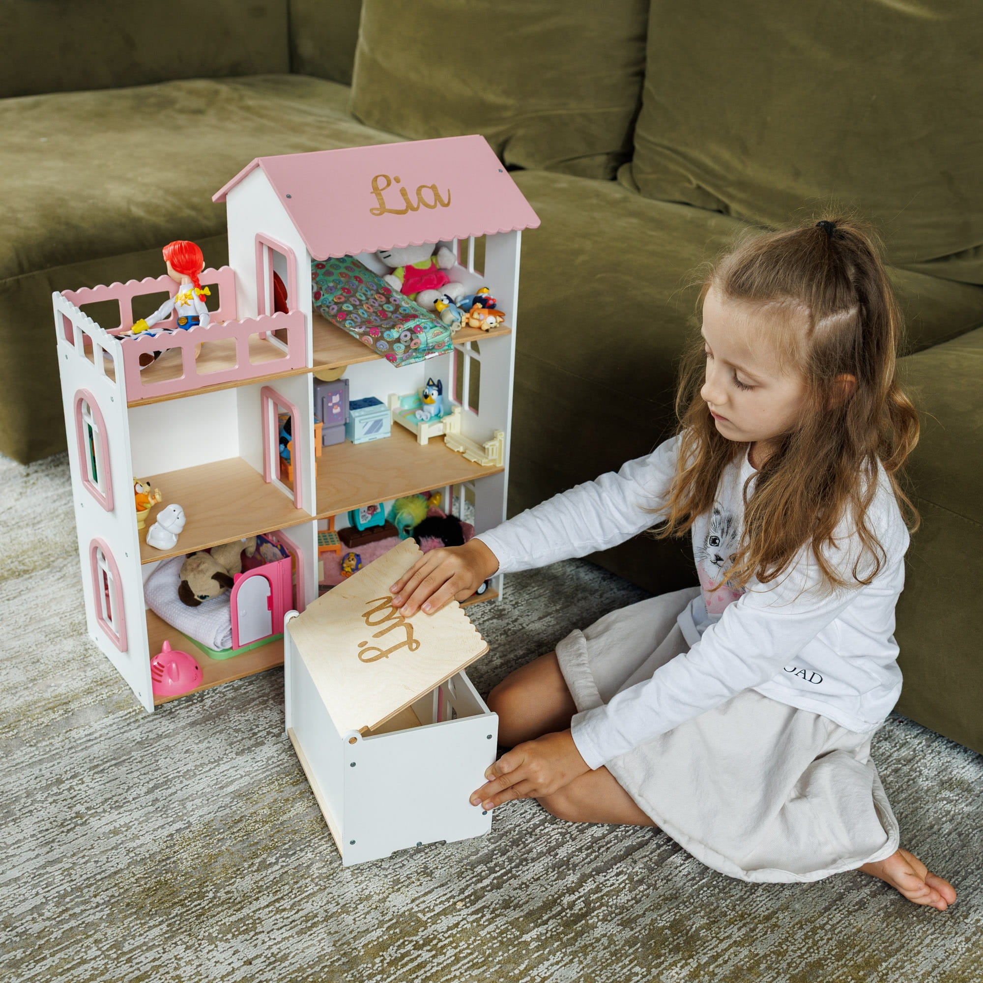 The dollhouse is white with pink trim and roof