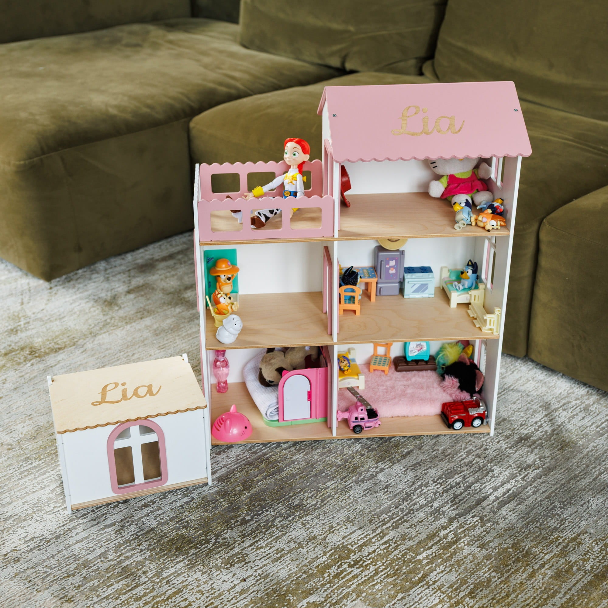 A personalized wooden dollhouse with a pink roof