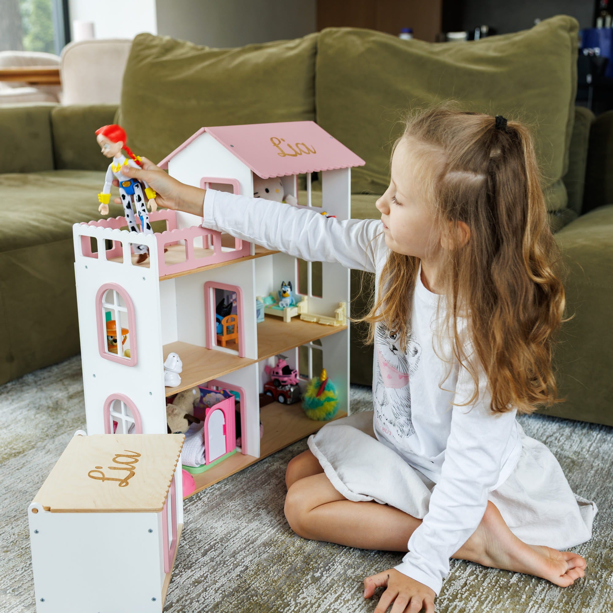 The dollhouse is white with pink trim and roof