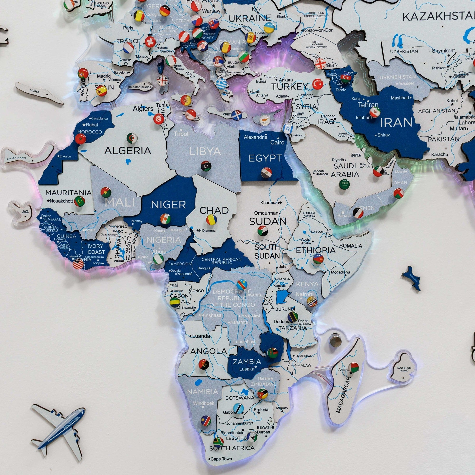 Map of Africa with pins and a toy airplane on a white background