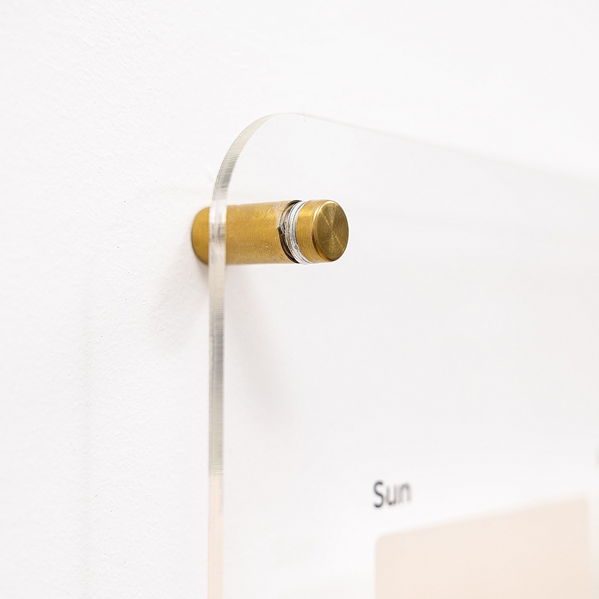 Decorative wall hook with gold and silver design on a white background