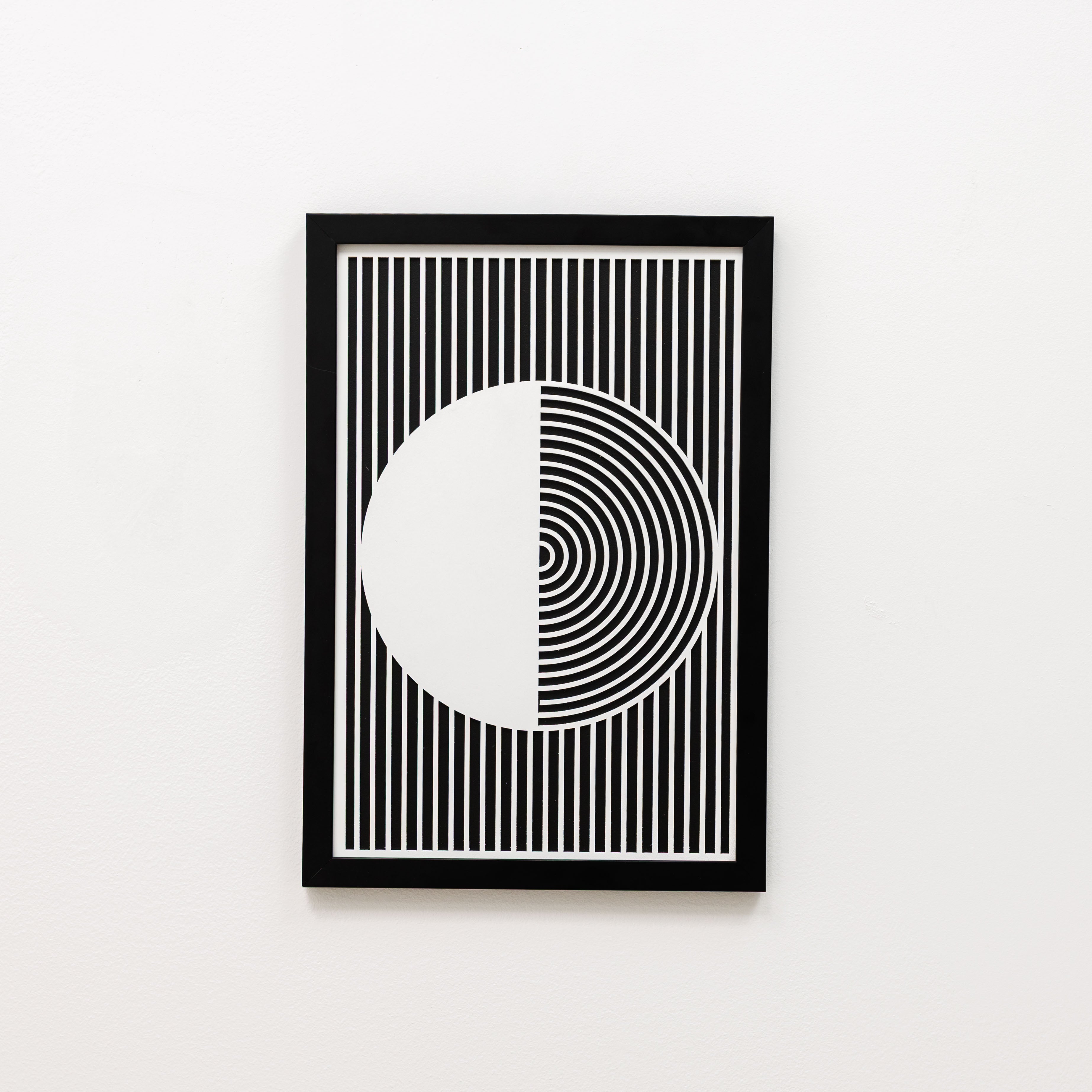 Framed black and white geometric art print on a white wall