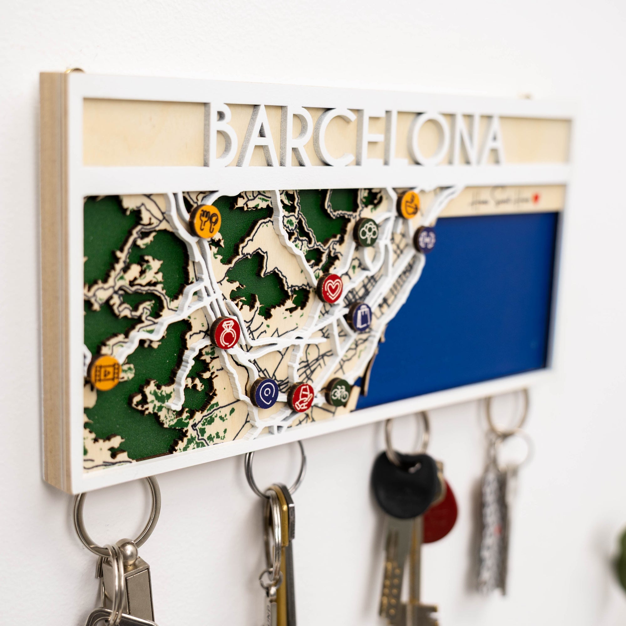 Key holder with a map of Barcelona and keychains attached, on a white background