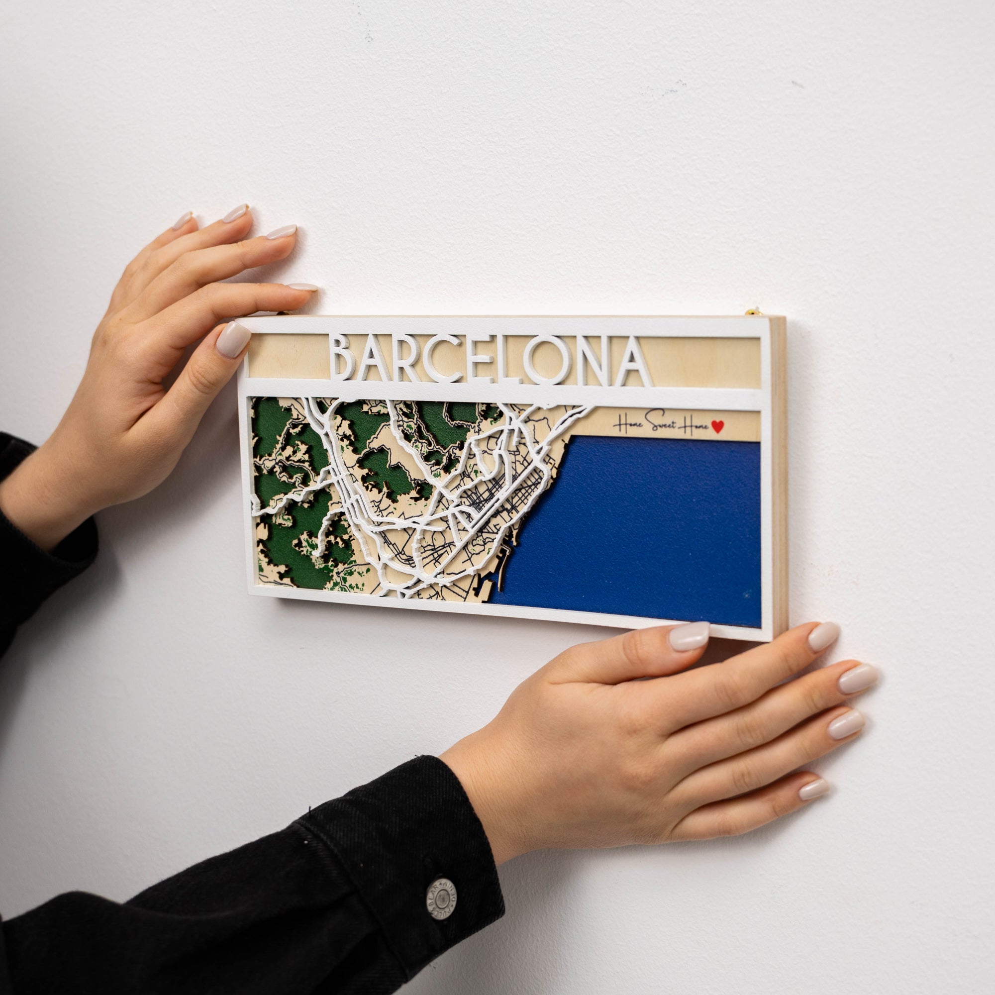 Wooden map of Barcelona held by a person on a white background
