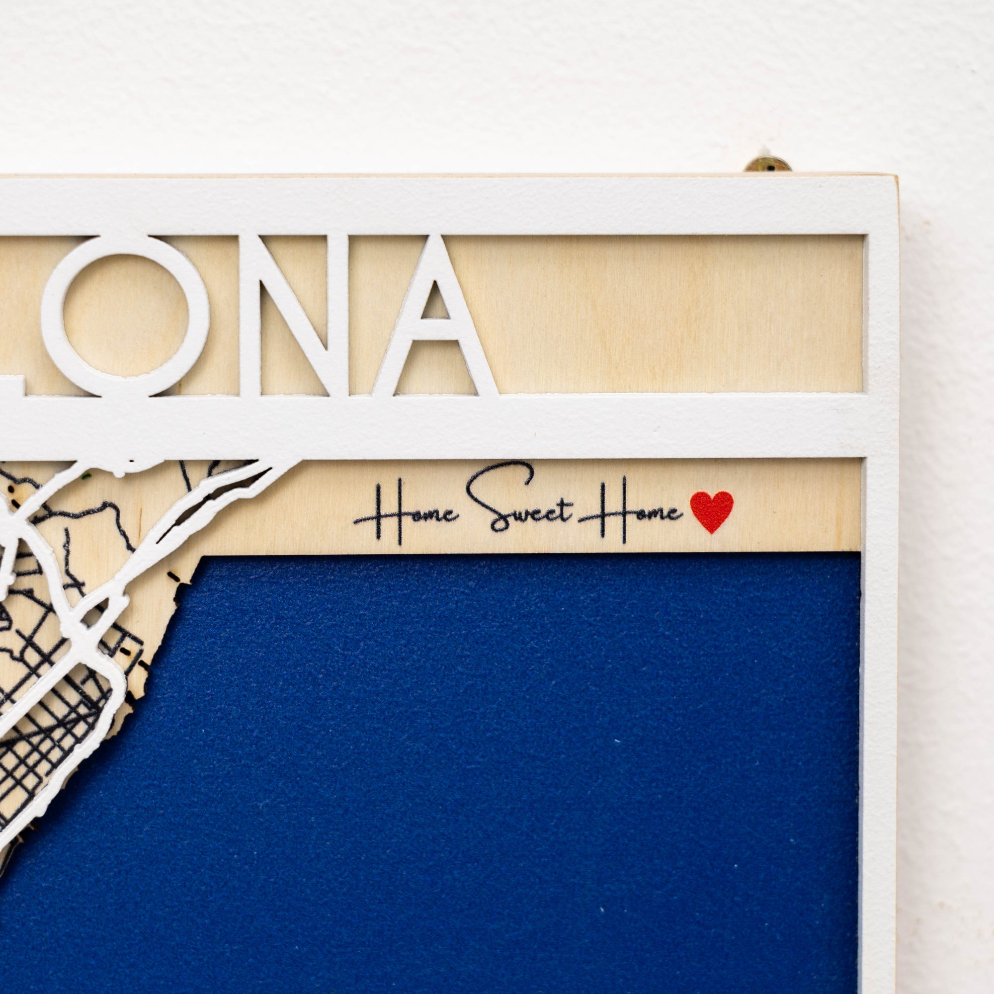 Decorative wall art with 'Home Sweet Home' text and map design on a blue background