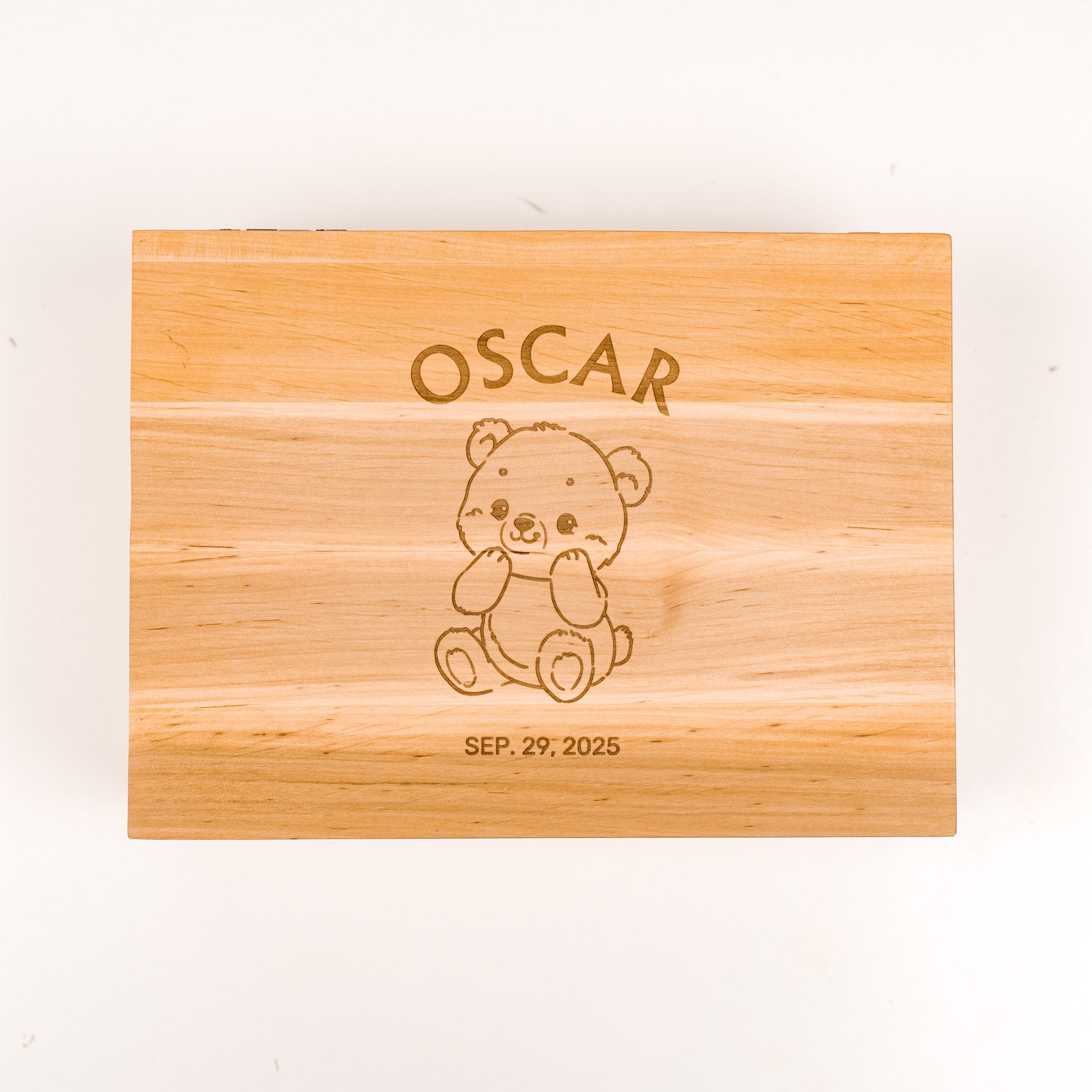Wooden box with engraved teddy bear and text on a white background