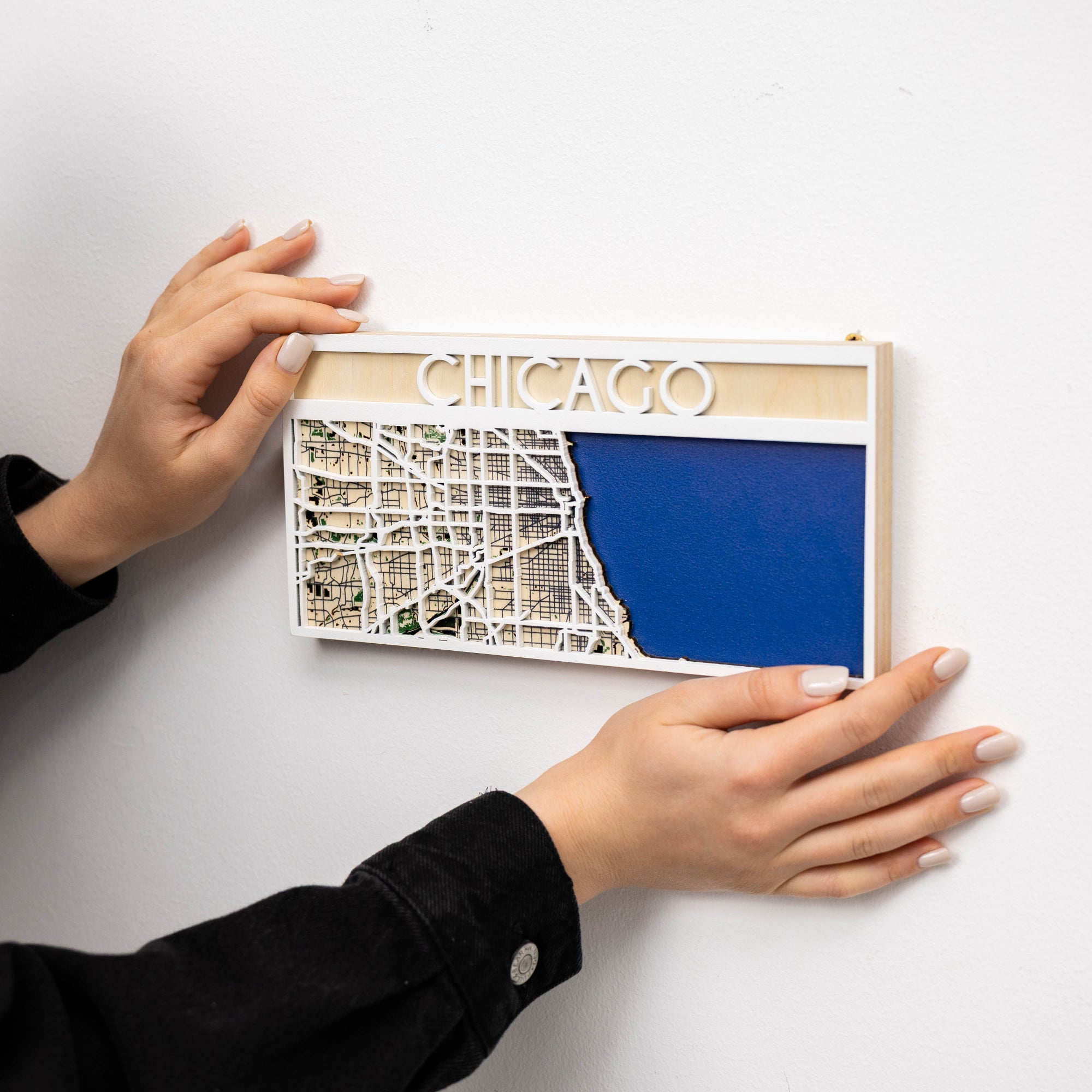 Person holding a framed map of Chicago on a white background