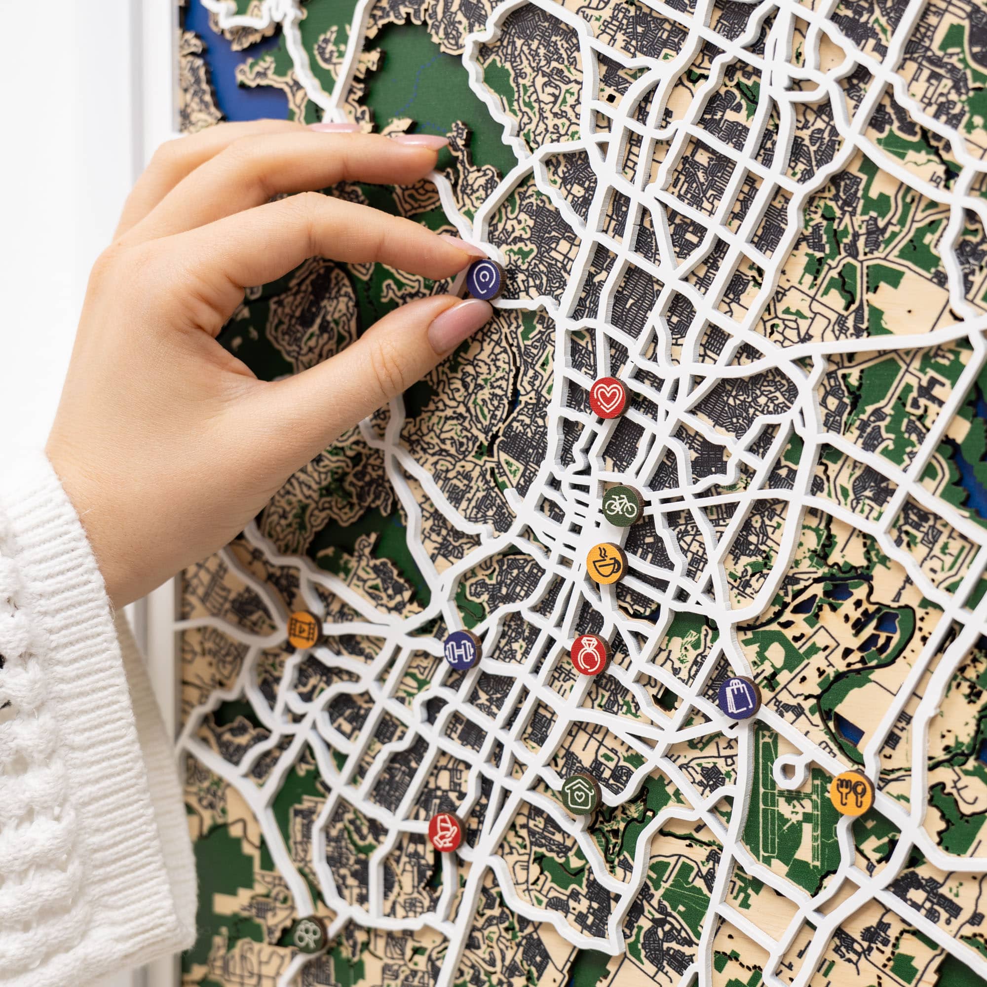 Hand placing colorful pins on a detailed map