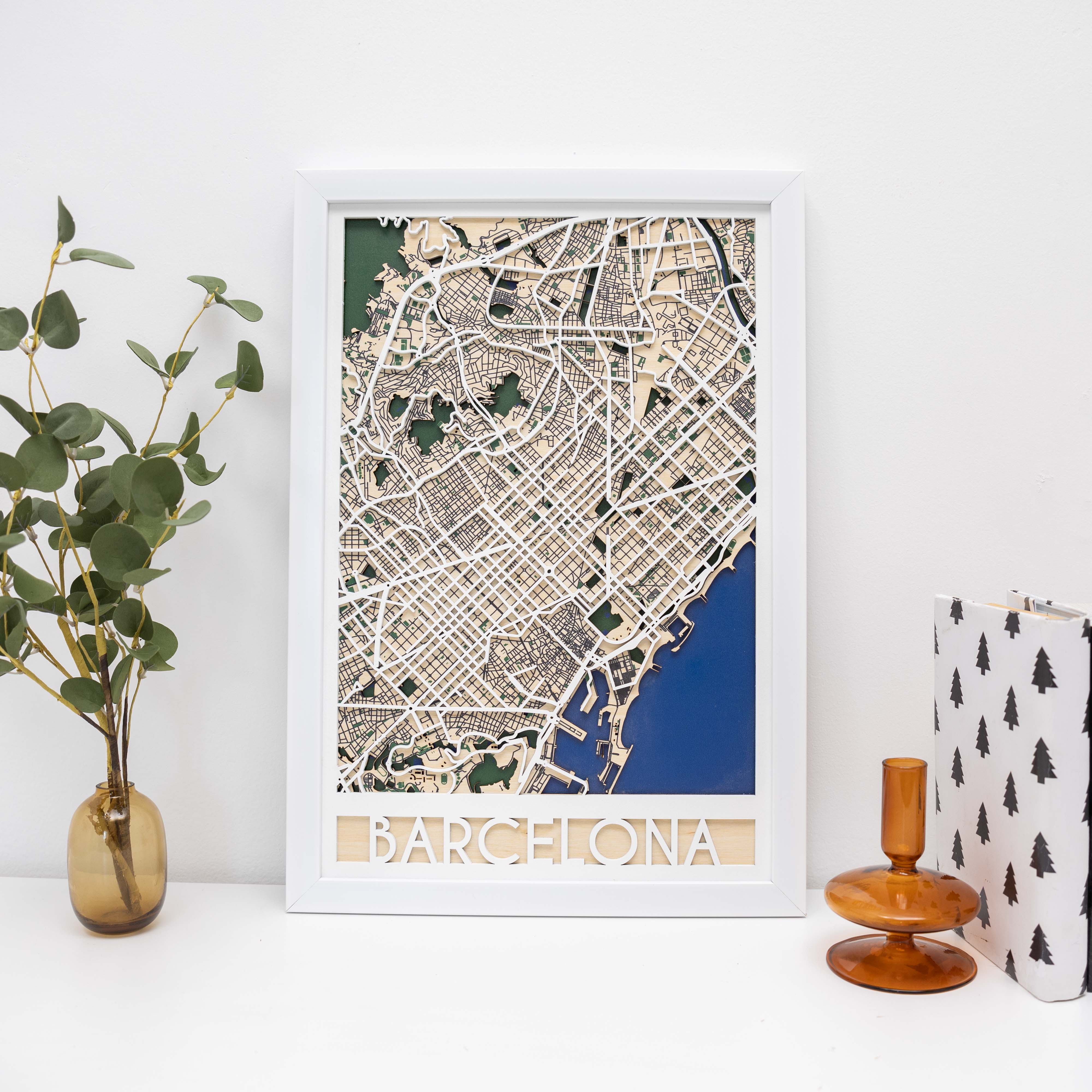 Framed map of Barcelona on a white surface with decorative items.