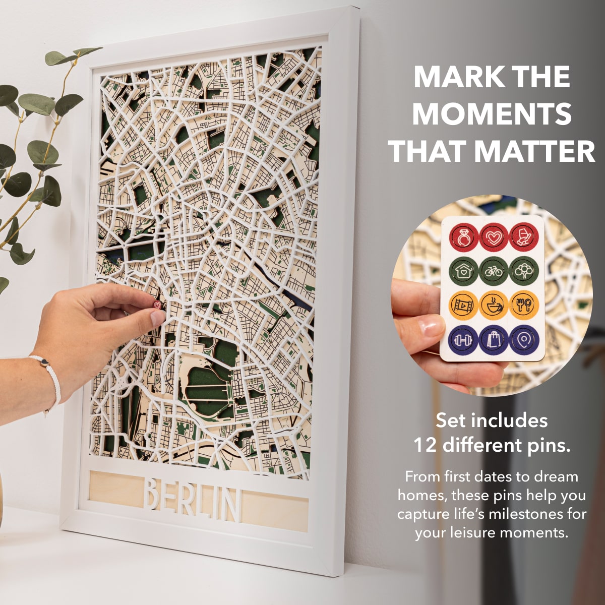 Framed map with decorative pins on a white surface, accompanied by an inset of pins and text.