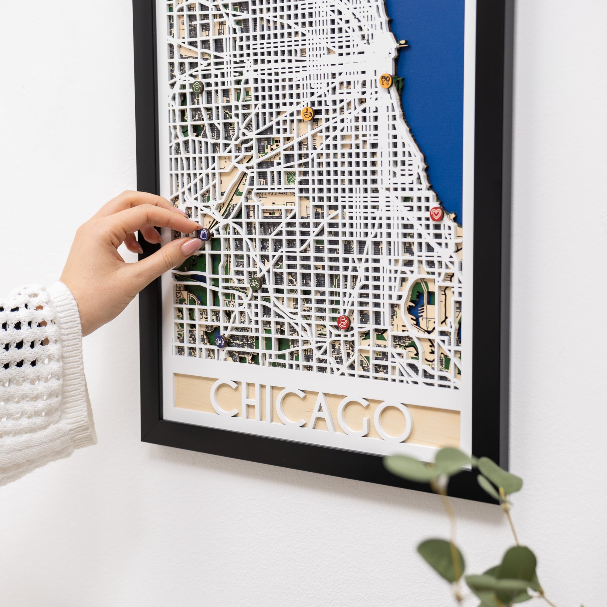 Framed map of Chicago with decorative elements on a white surface.
