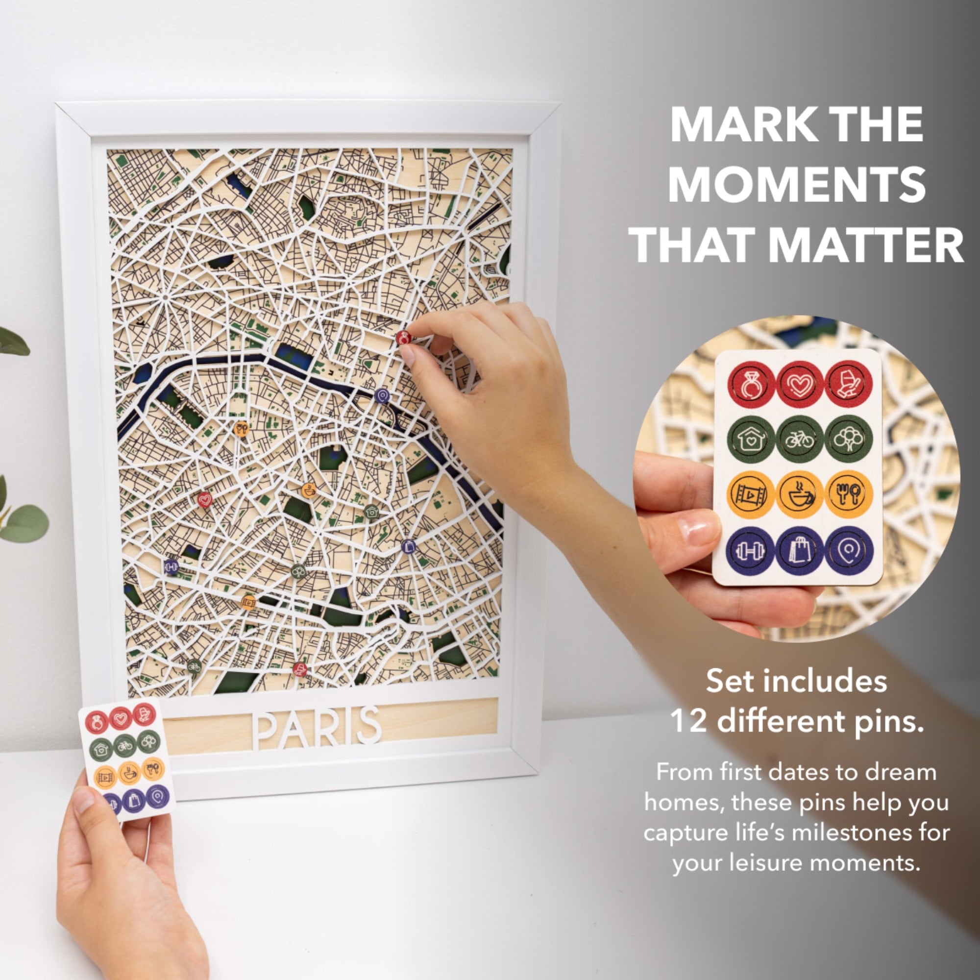 Framed map of Paris with decorative pins on a white surface