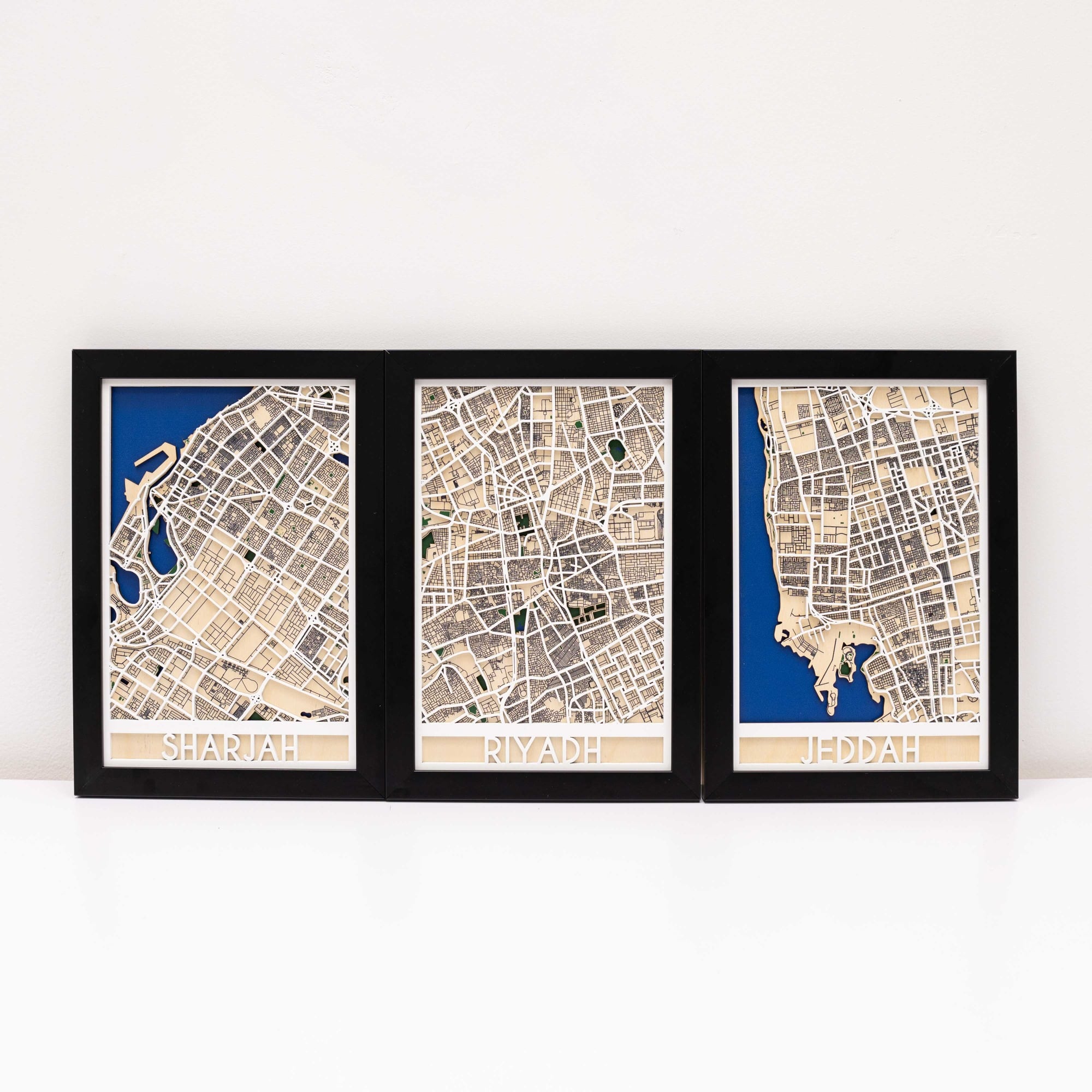 Three framed maps of different cities on a white background