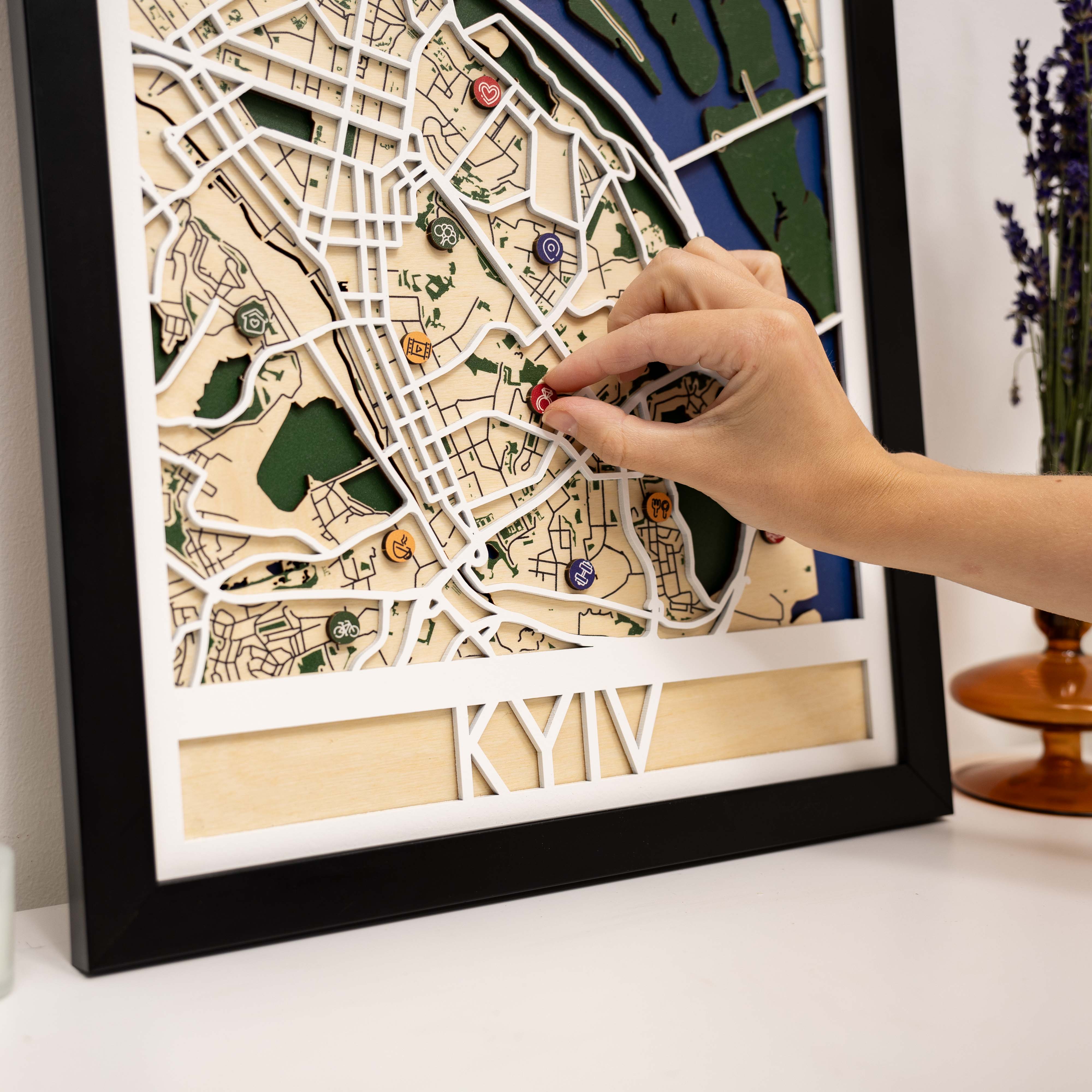 Framed city map with decorative pins on a white surface