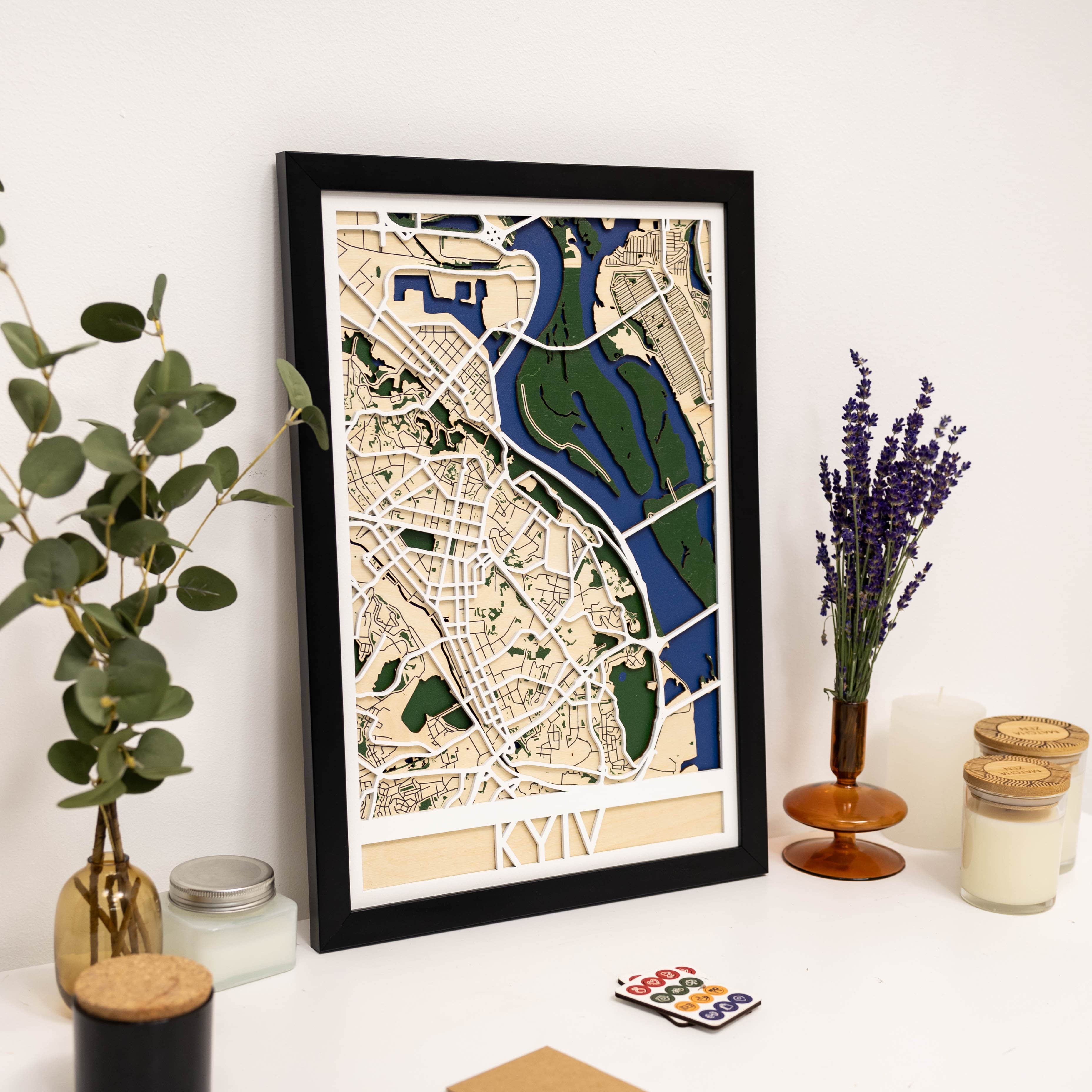 Framed city map of Kyiv on a white surface with decorative items.