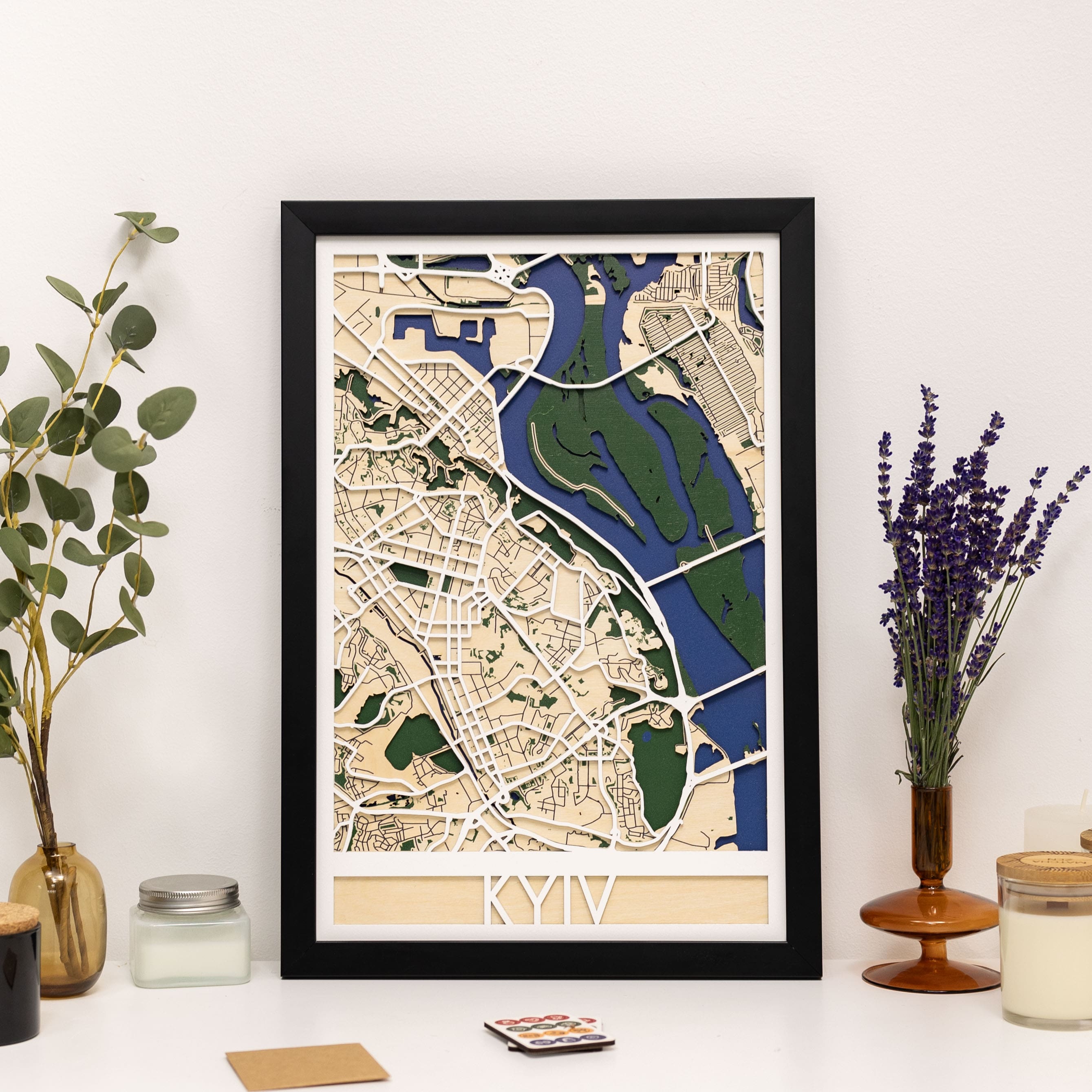 Framed map of Kyiv on a white wall with decorative elements.