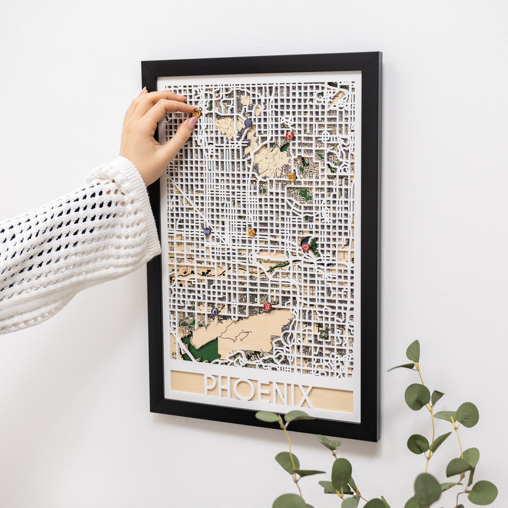 Framed map of Phoenix with decorative elements on a white wall.