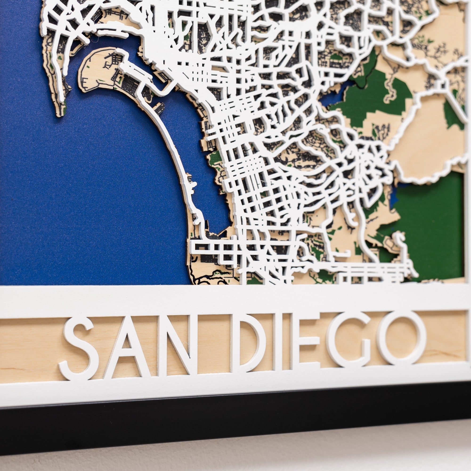 Wooden map of San Diego with street details on a blue background