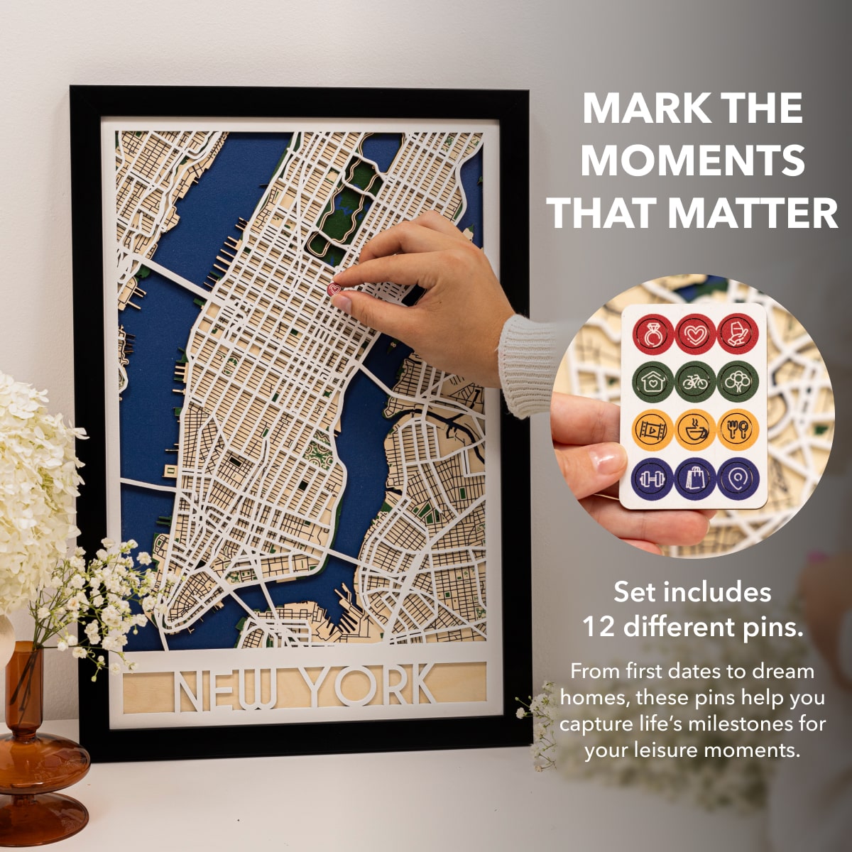 Framed map of New York with decorative pins on a white surface.