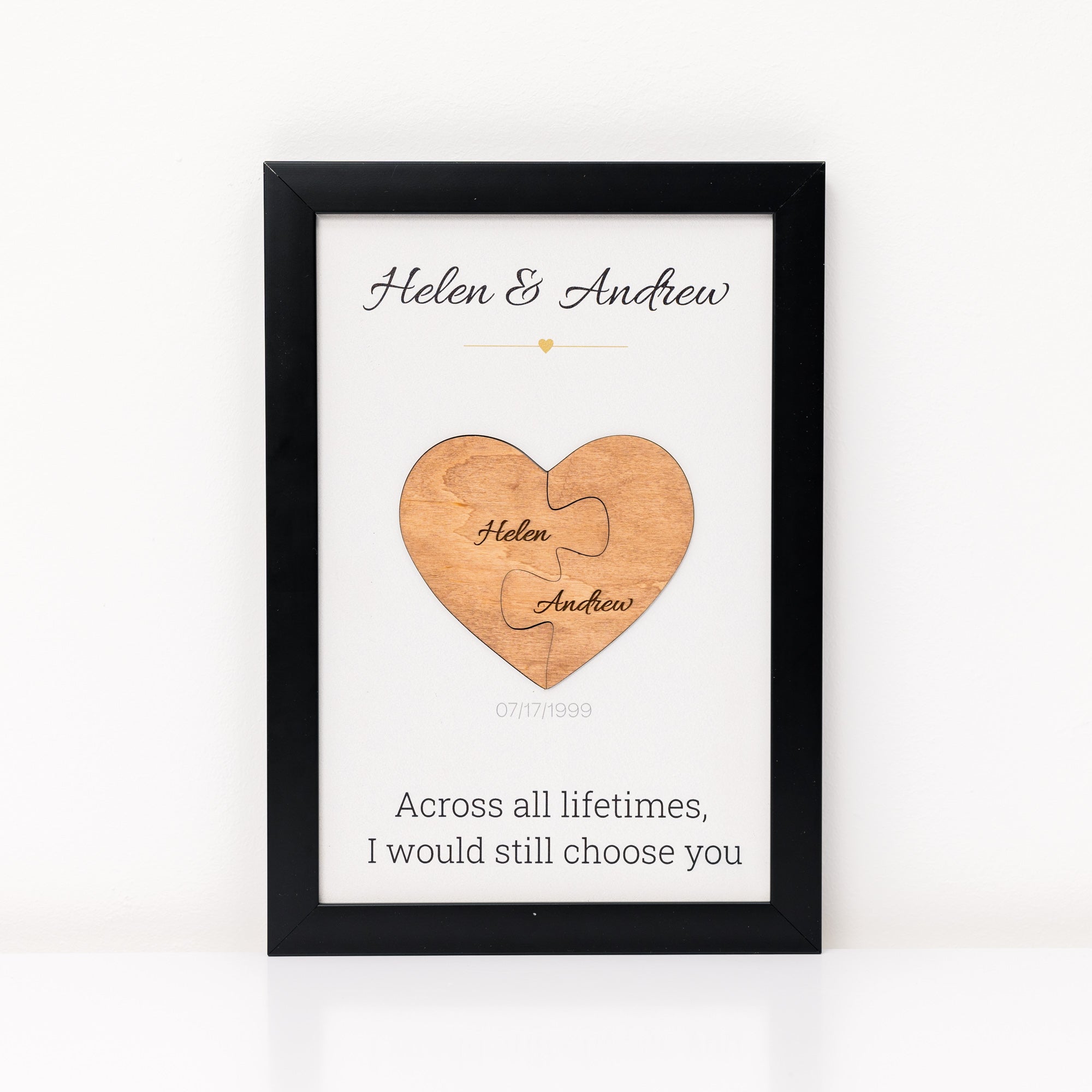 Framed wooden heart puzzle with engraved names and romantic quote on a white background